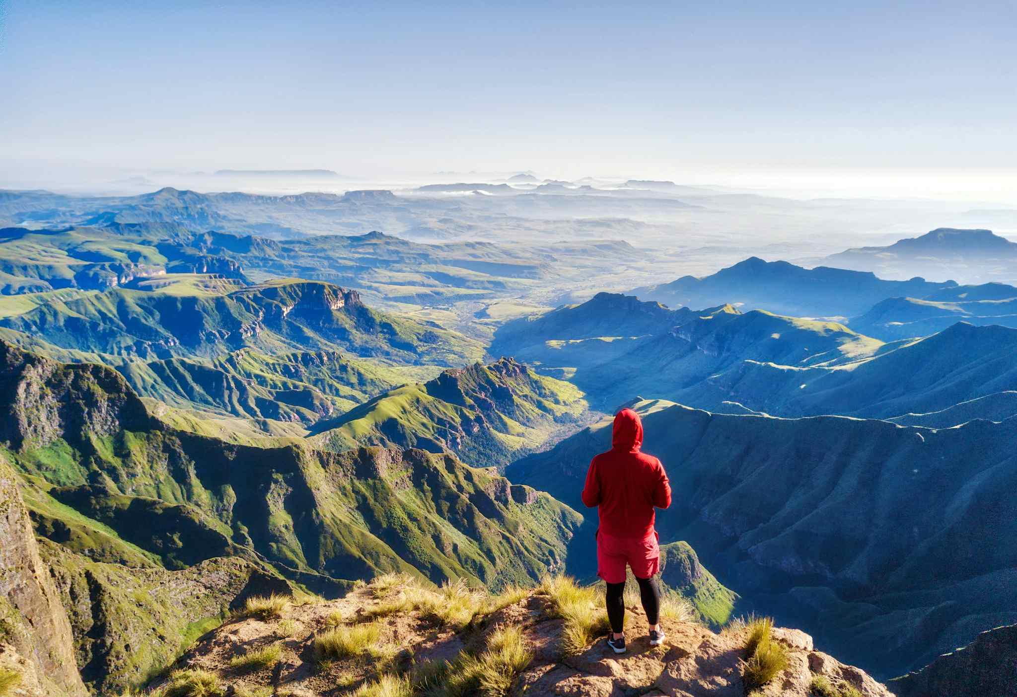 Hiker overlooking Drakensberg mountains from Amphitheatre, South Africa. Photo: GettyImages-1140319738