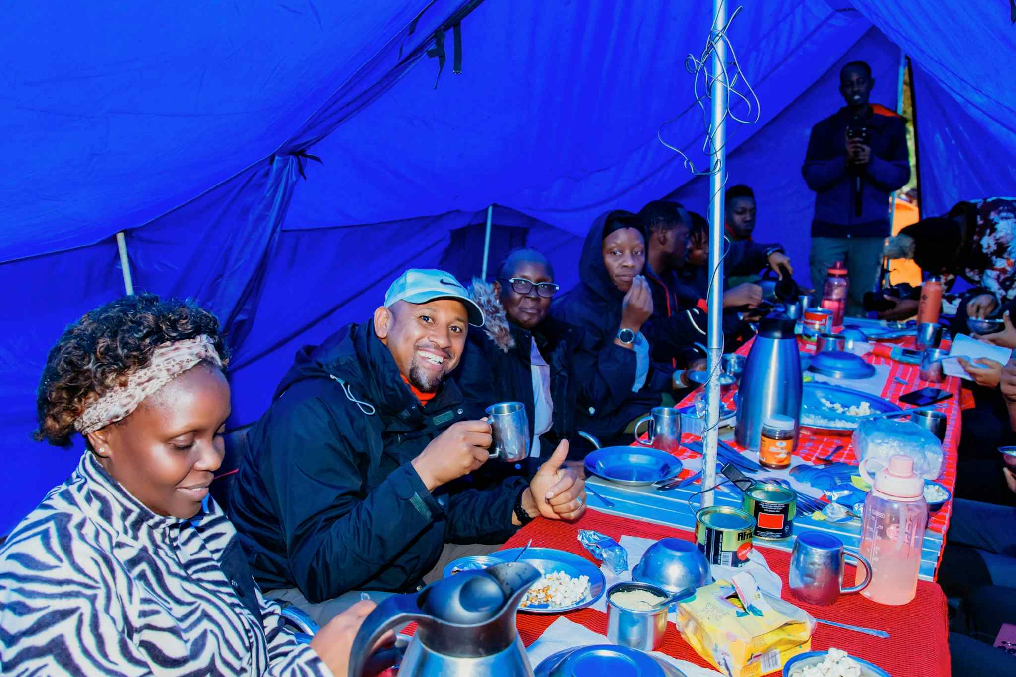 People enjoying a meal in a mess tent on Mount Kilimanjaro, Tanzania.