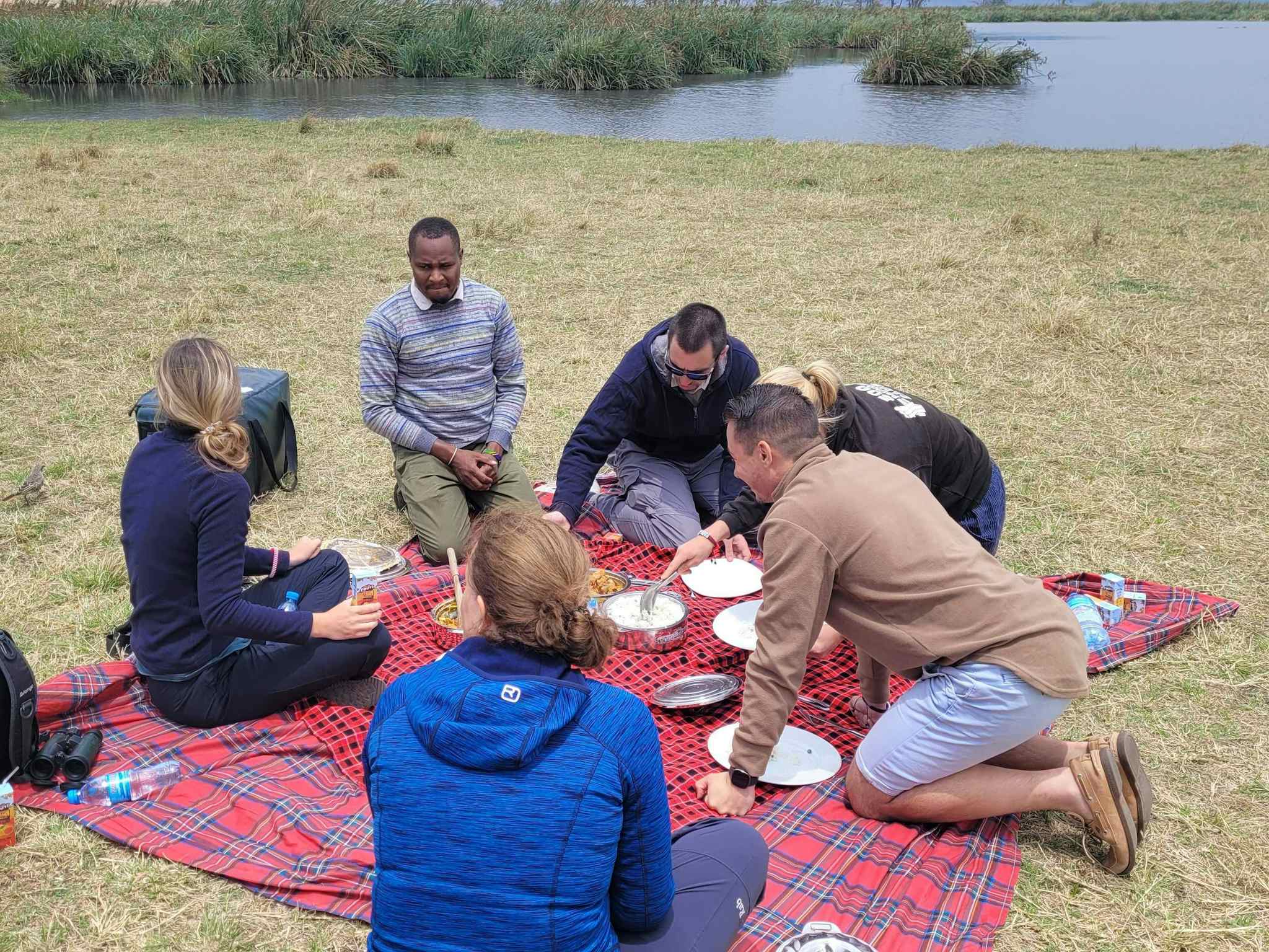 Group of people having a picnic by a lake in Ngorongoro Crater, Tanzania