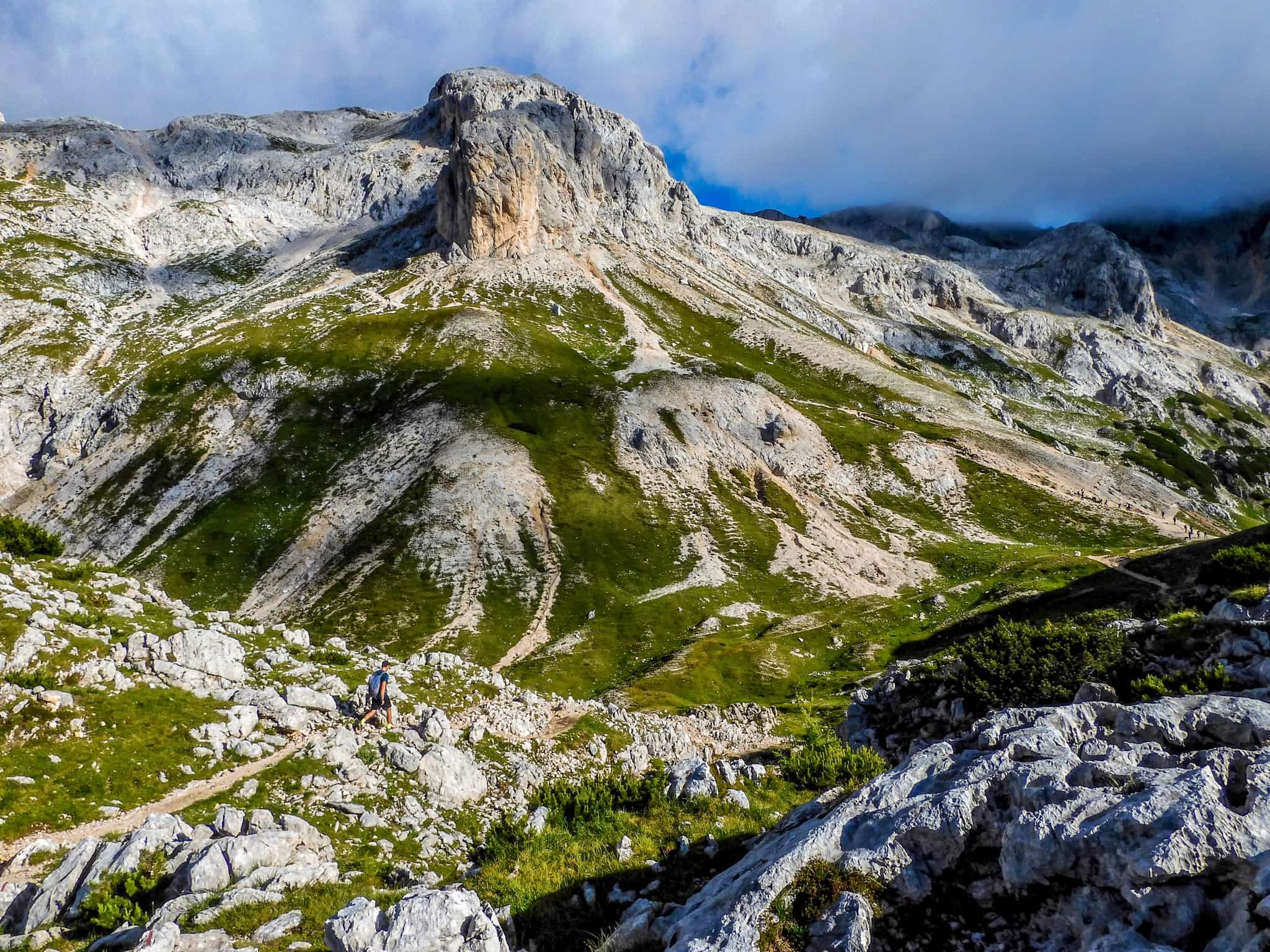 Hiker walking through the rocky peaks of the Julian Alps