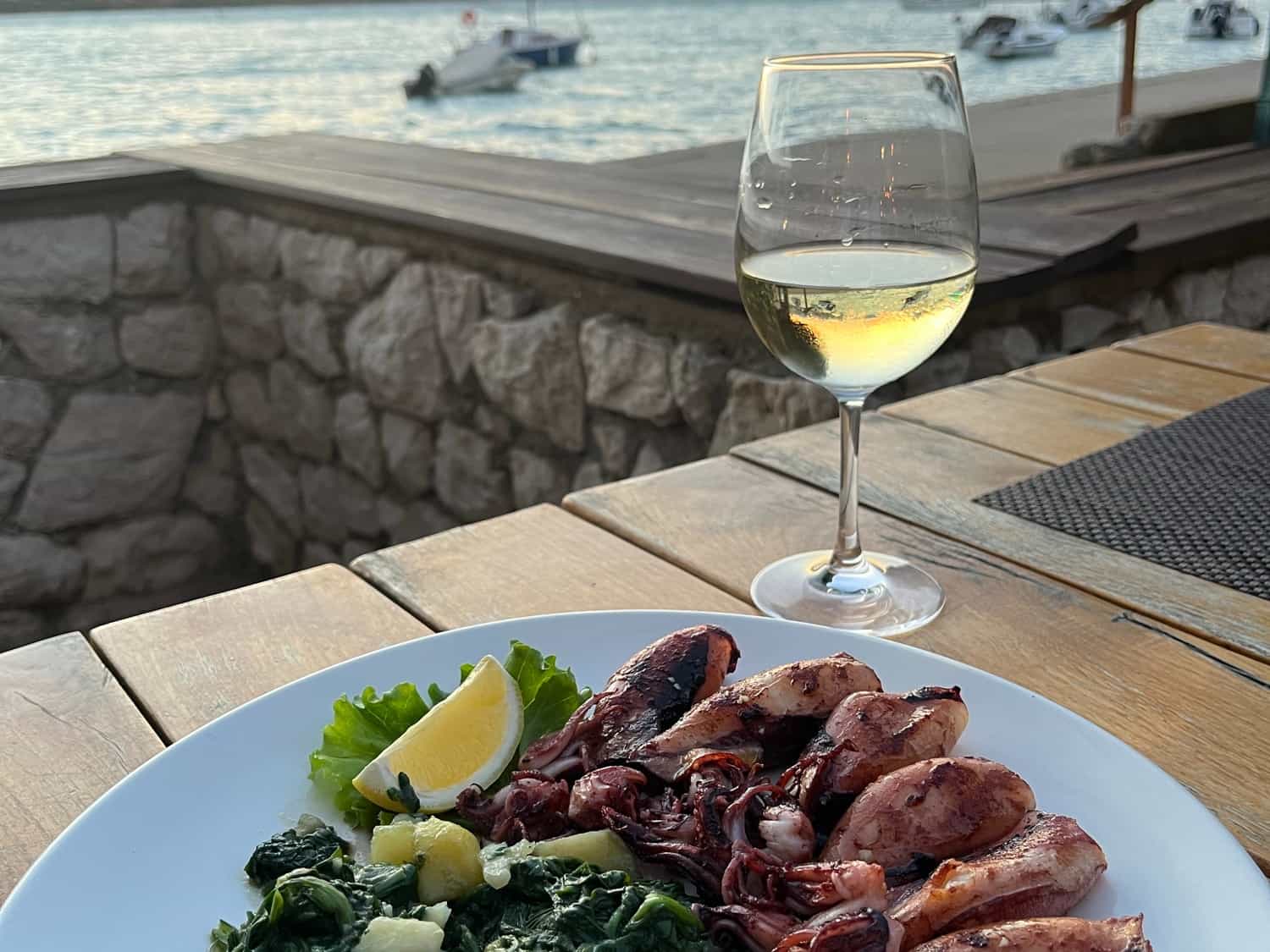 Island of Pag - Grilled squid with a side dish (potatoes and spinach) with cold white wine
