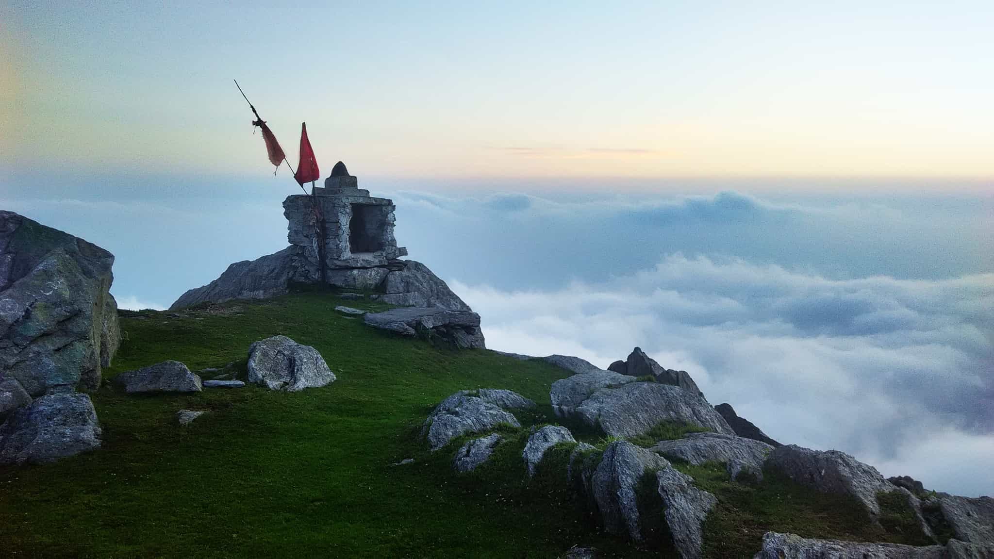 Mountaintop shrine on a rocky cliff with clouds below