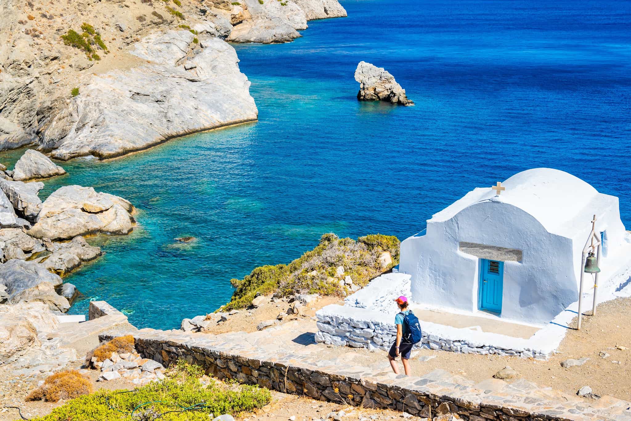 Hiker along a coastal trail in Naxos Coast, Greece.
