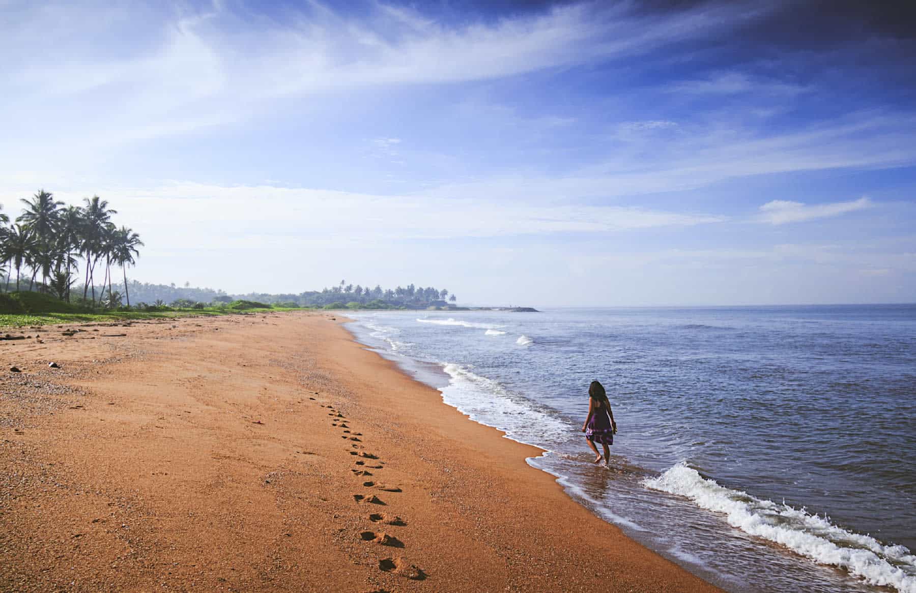 Person walking along Waikkal beach in Sri Lanka