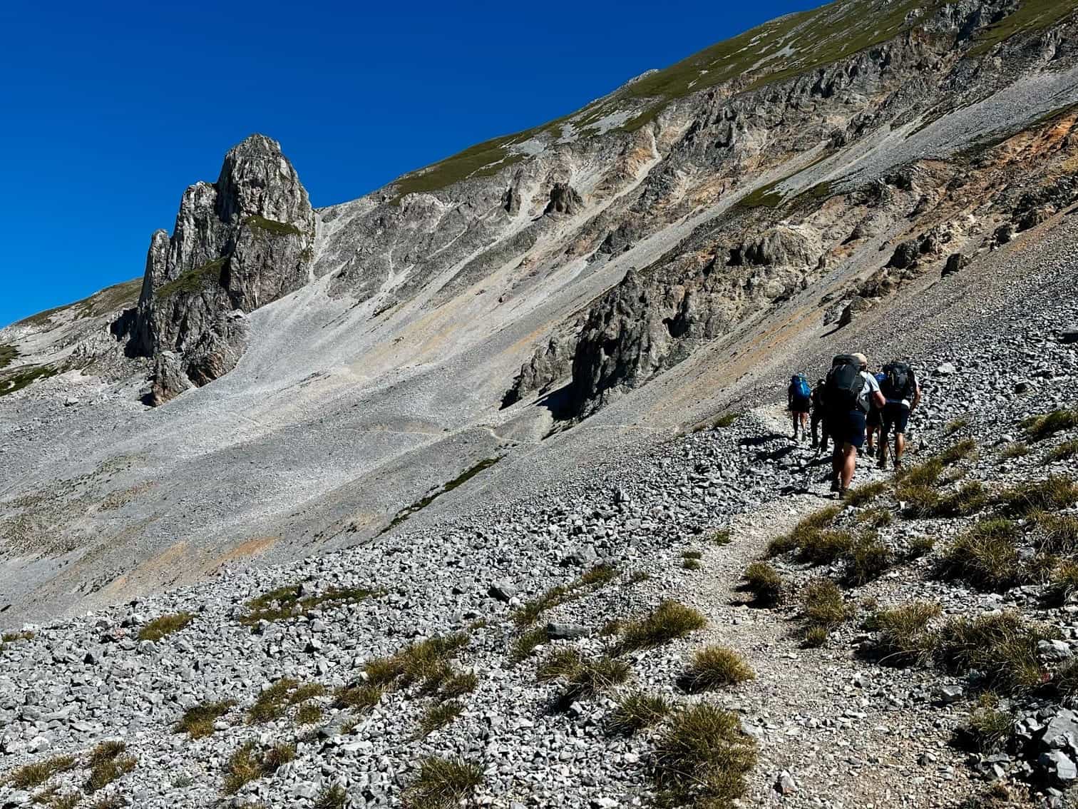 Hikers on a trail through scree in the Sharr Mountains.