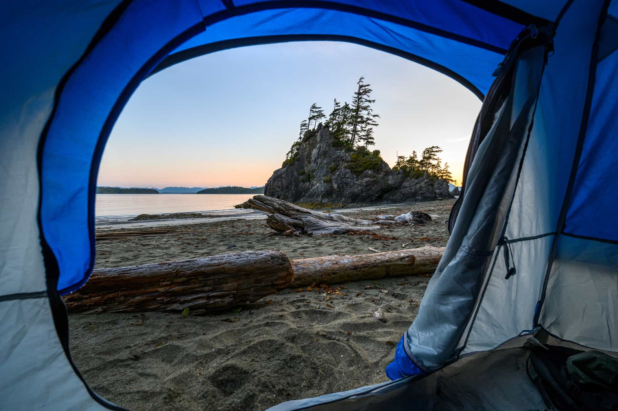 A view of the beach through the opening of a tent.