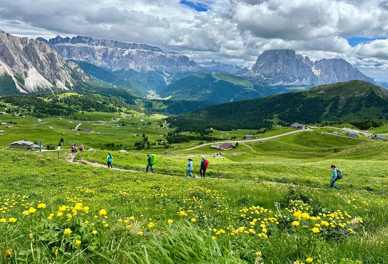 Hikers with Odle Group peaks in the background.