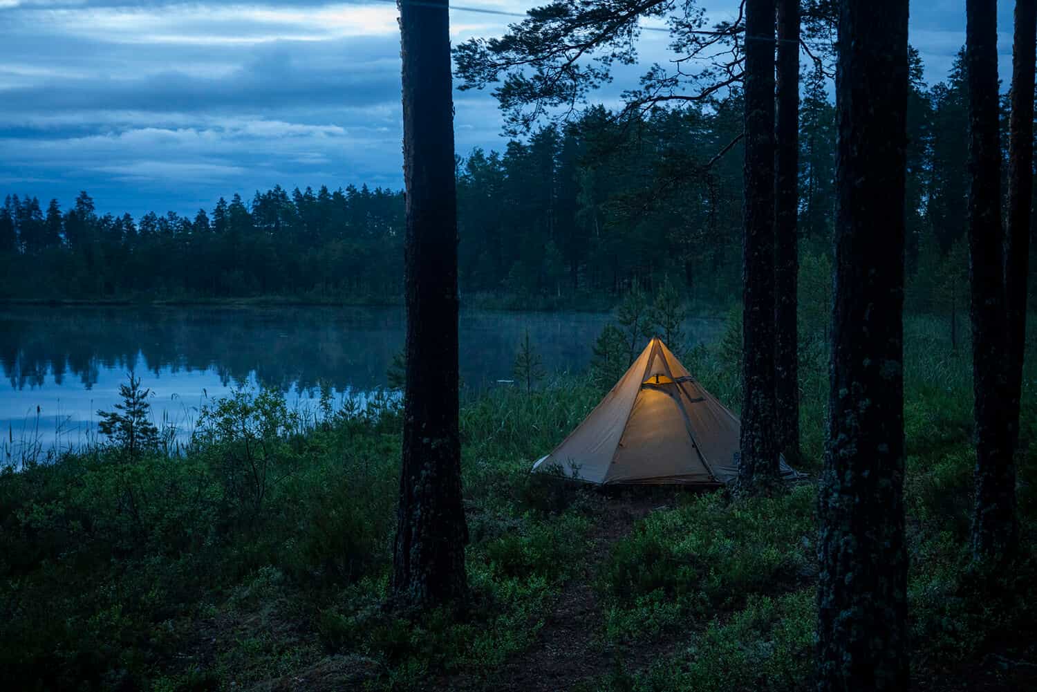 Tent by a lake in the forests of Sweden.