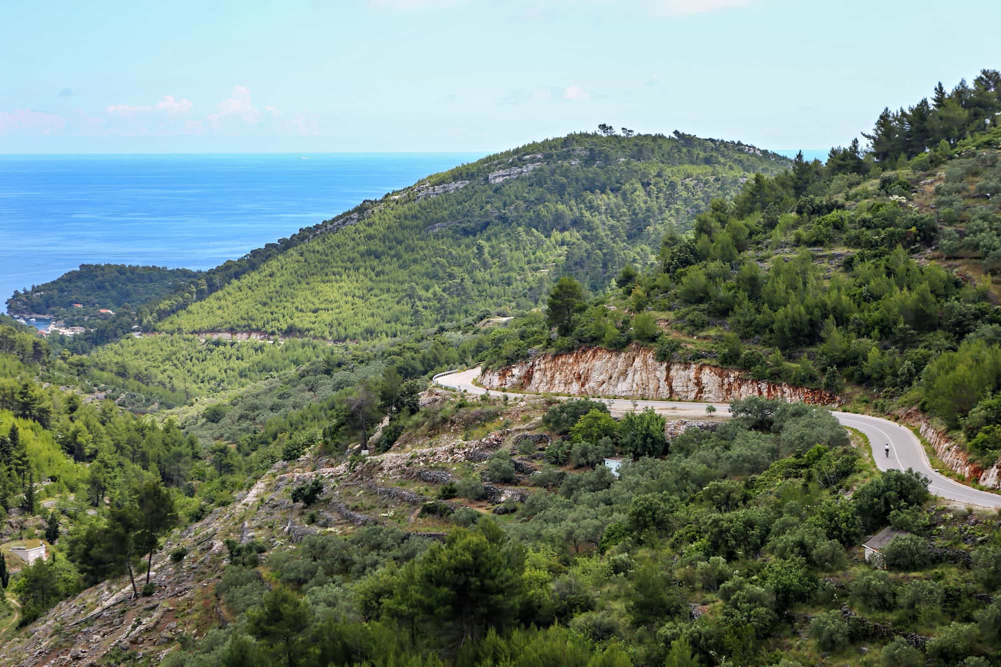 Looking down a long road to the sea on a biking journey in Croatia.