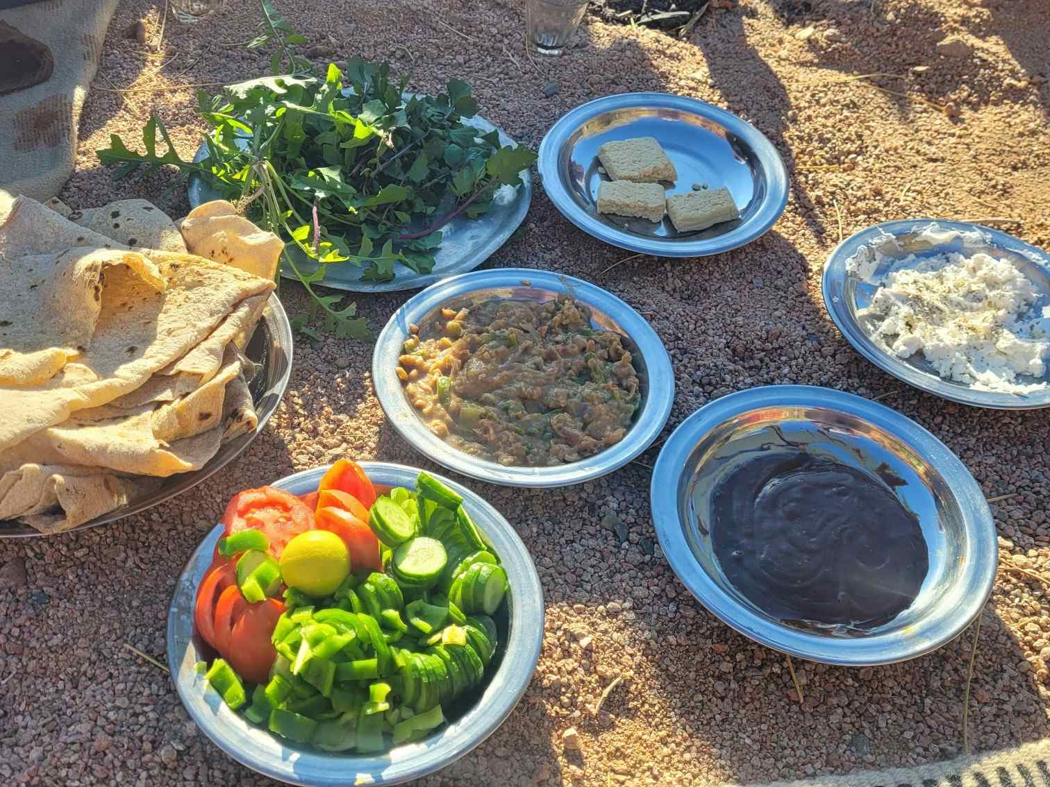 A selection of fresh Egyptian Bedouin-style dishes, including flatbreads, salad, fuul, cheese and honey