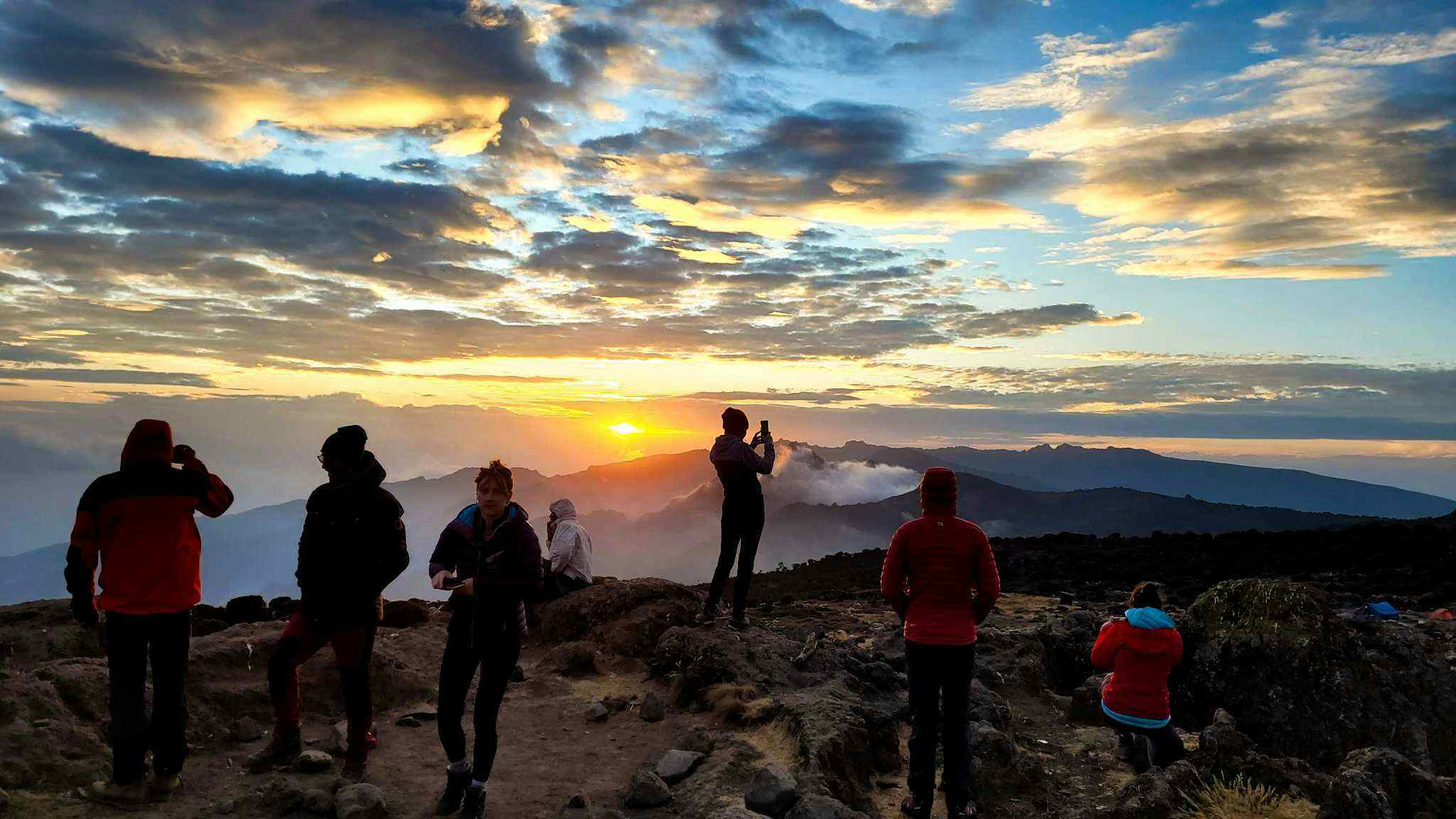 Trekkers admiring the sunset from Shira Camp on Mount Kilimanjaro, Tanzania