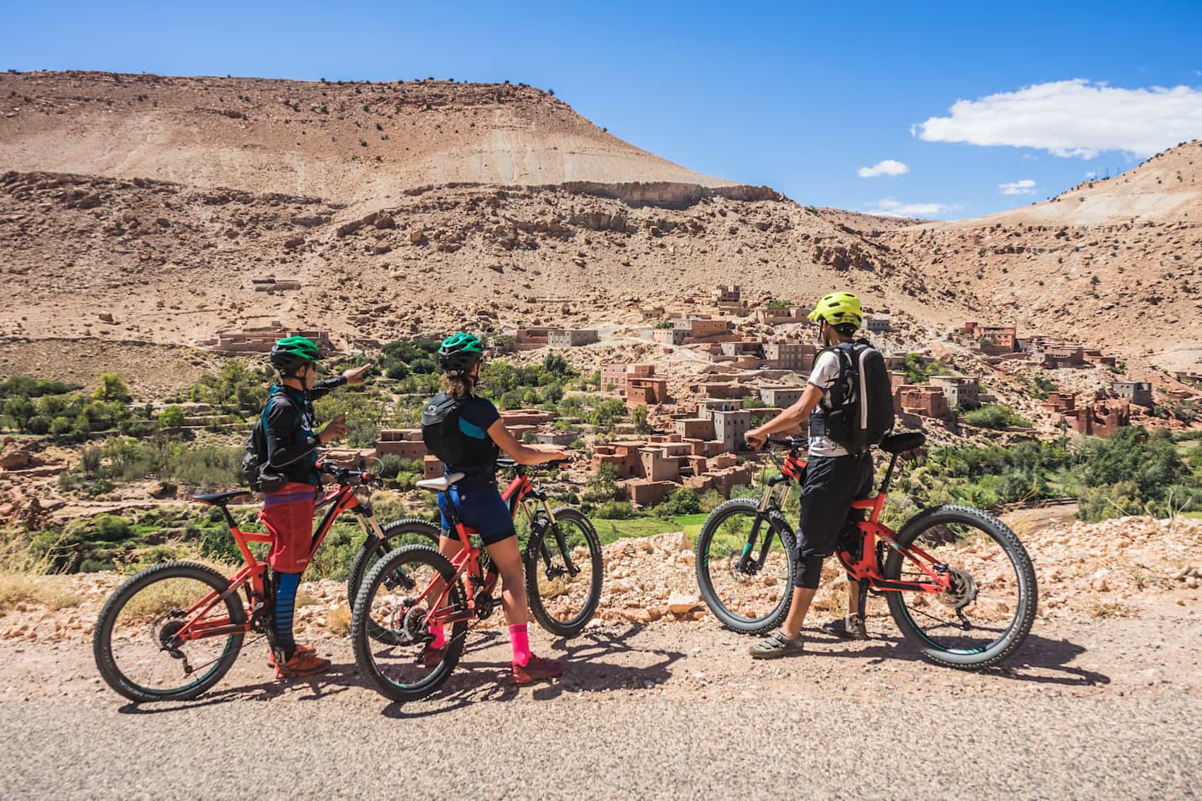 A group of cyclists looking over to a Moroccan town.