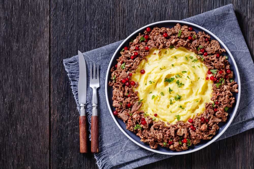 A dish of traditional Norwegian reindeer stew with lingonberries.