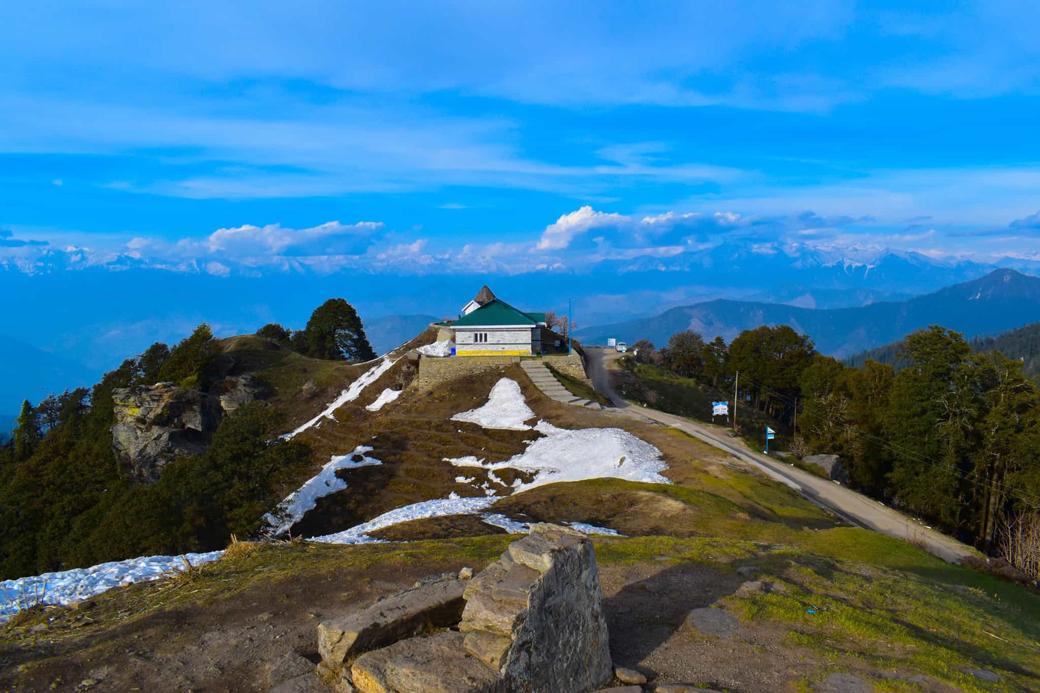 View of the rest house on the ridge of Hatu Peak, with the Himalayan Peaks in the background