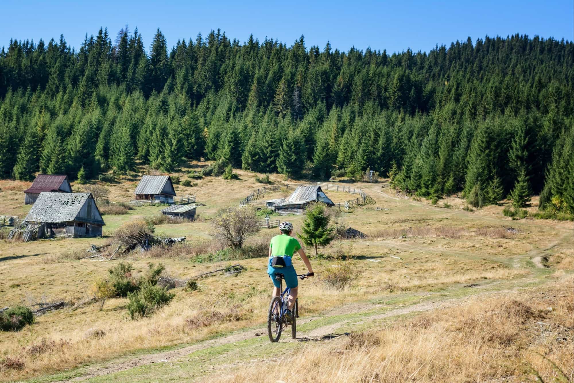 Cross country biker on a dusty mountain road on a sunny day, Romania