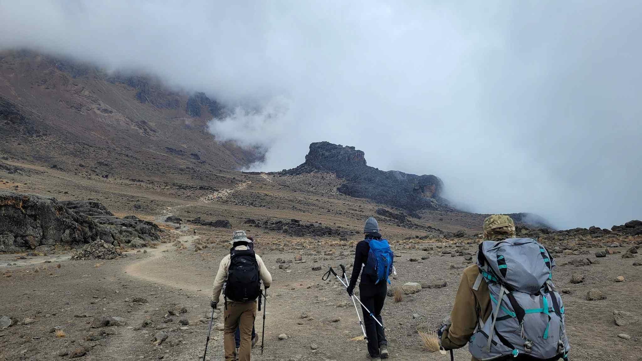 Three trekkers on the Machame Route approaching Lava Tower, Kilimanjaro, Tanzania.