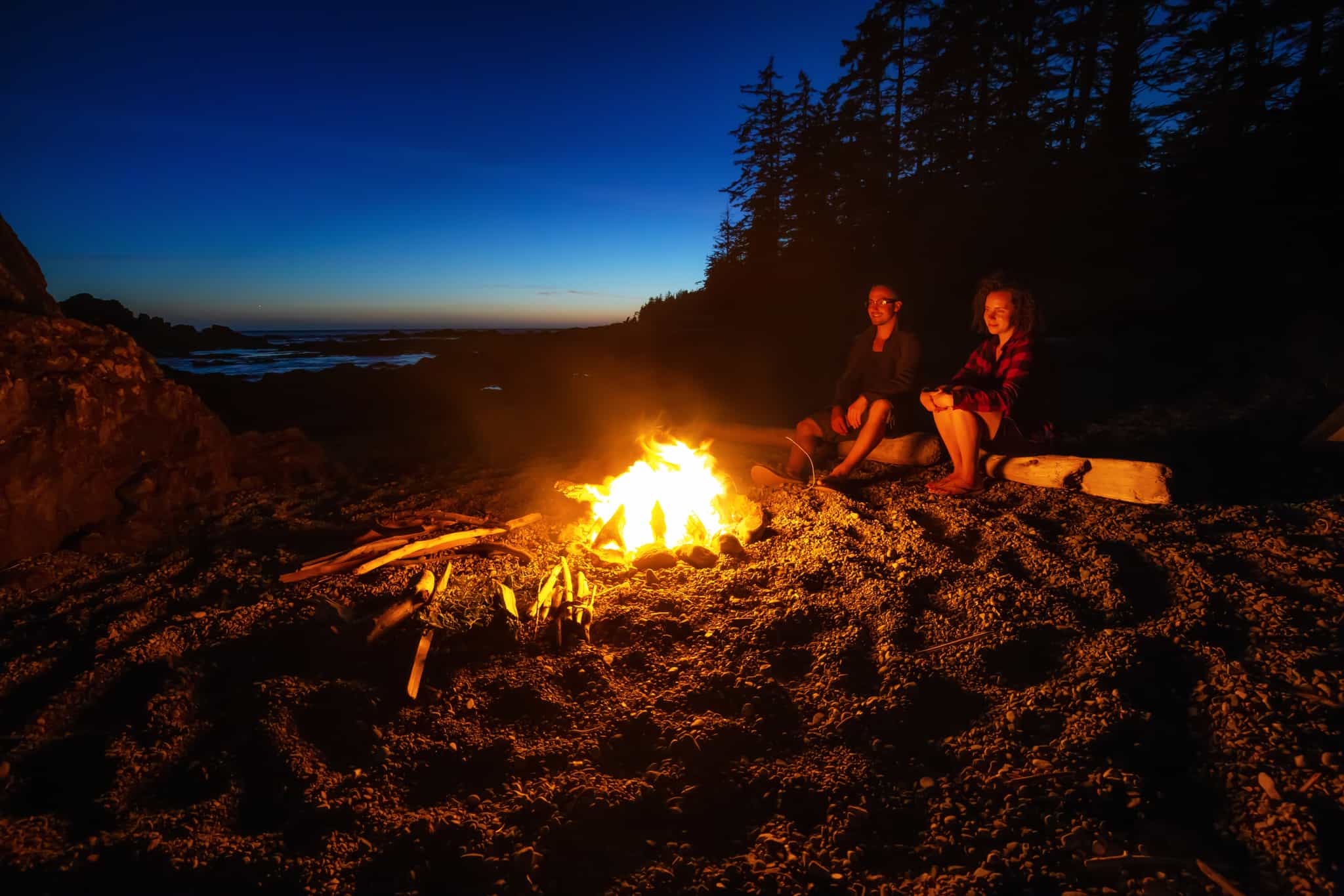 Travellers round the campfire on Vancouver Island, Canada.