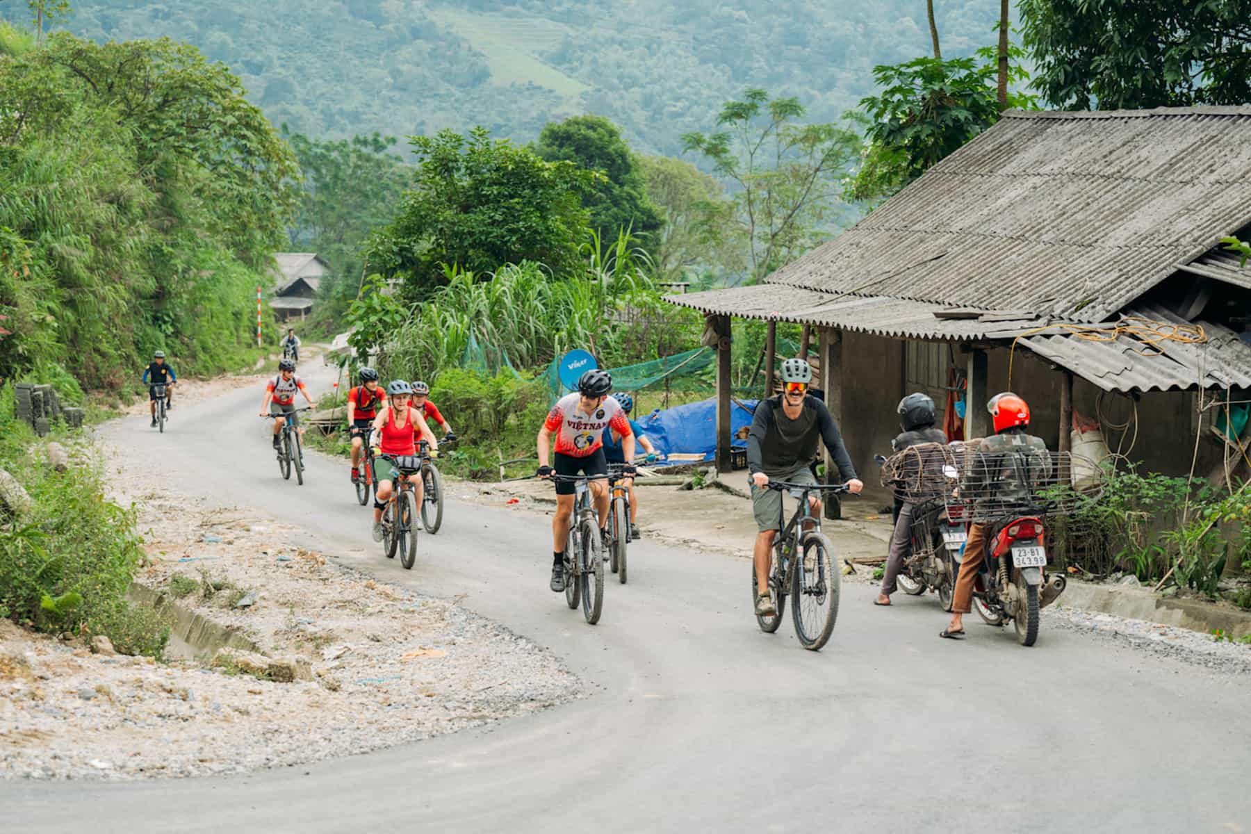 Cycle group in north Vietnam, passing through village