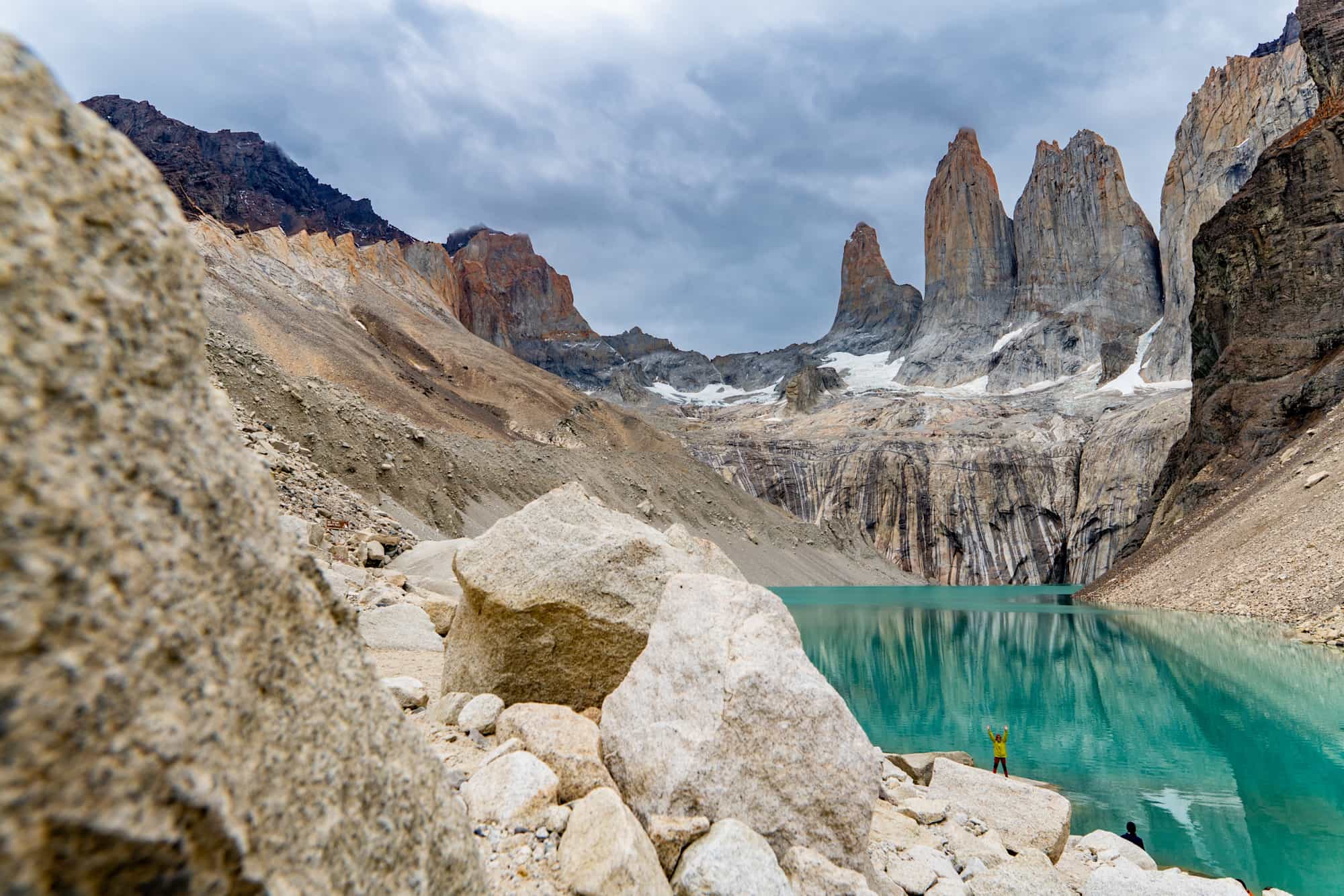 Hiker celebrating in front of the Torres viewpoint of Tores del Paine