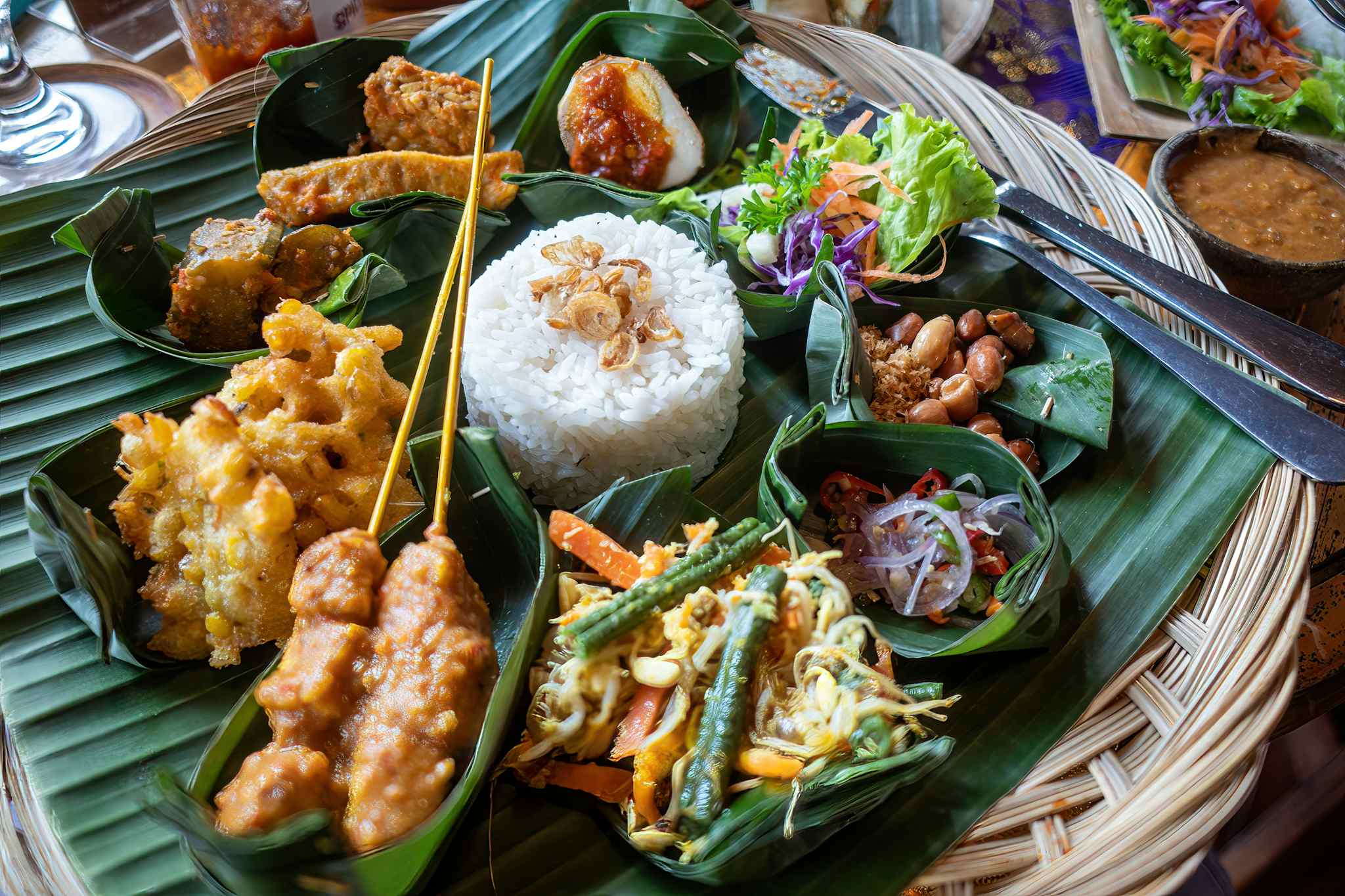 An Indonesian dinner consisting of small dishes including satay, rice, tempeh and salads in Bali.