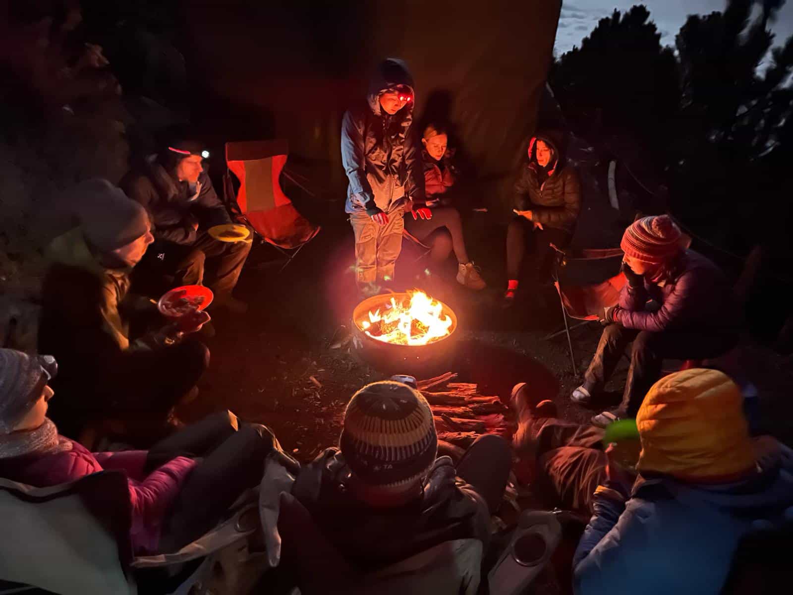 A group sit around the camp fire at Acatenango Volcano, Guatemala.
