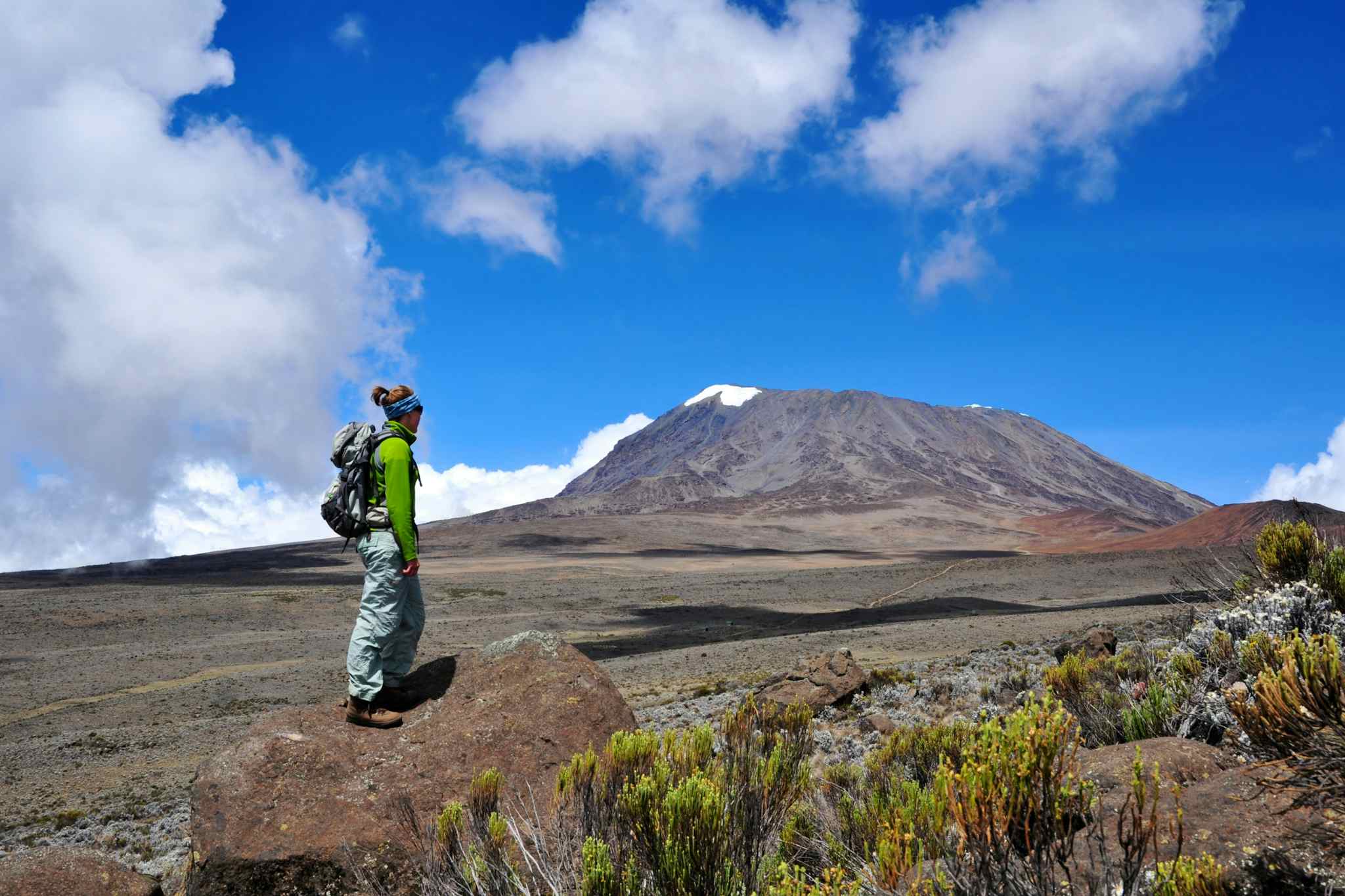 Female hiker looking up to Kilimanjaro's peak in Tanzania.