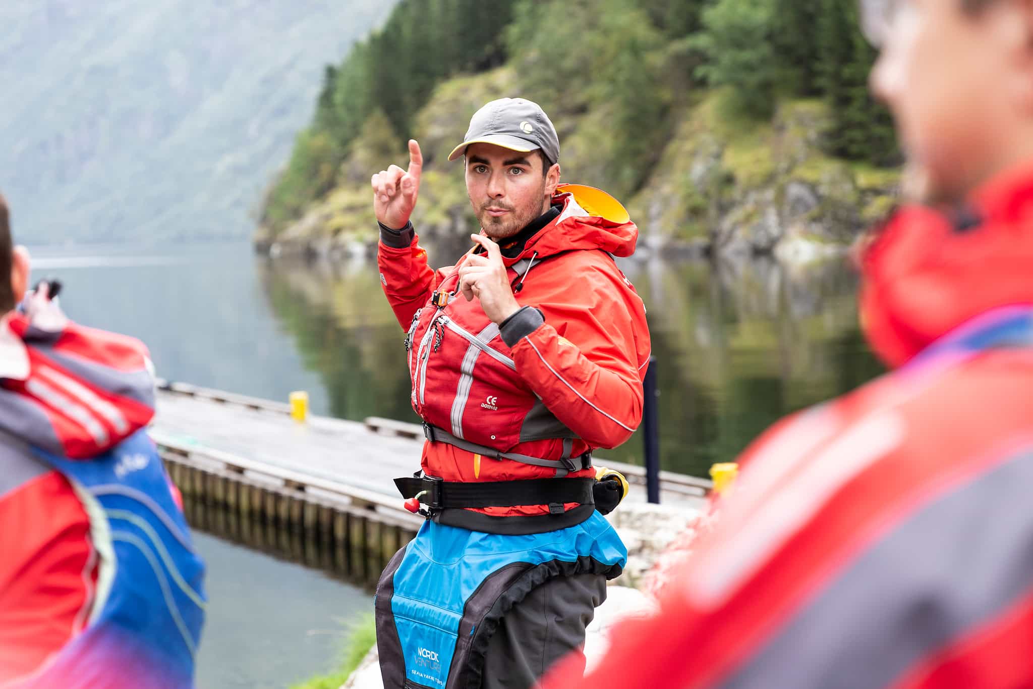 A kayaking guide takes a group of kayakers through a safety briefing on the edge of the Naeroyfjord in the Norwegian Fjords.