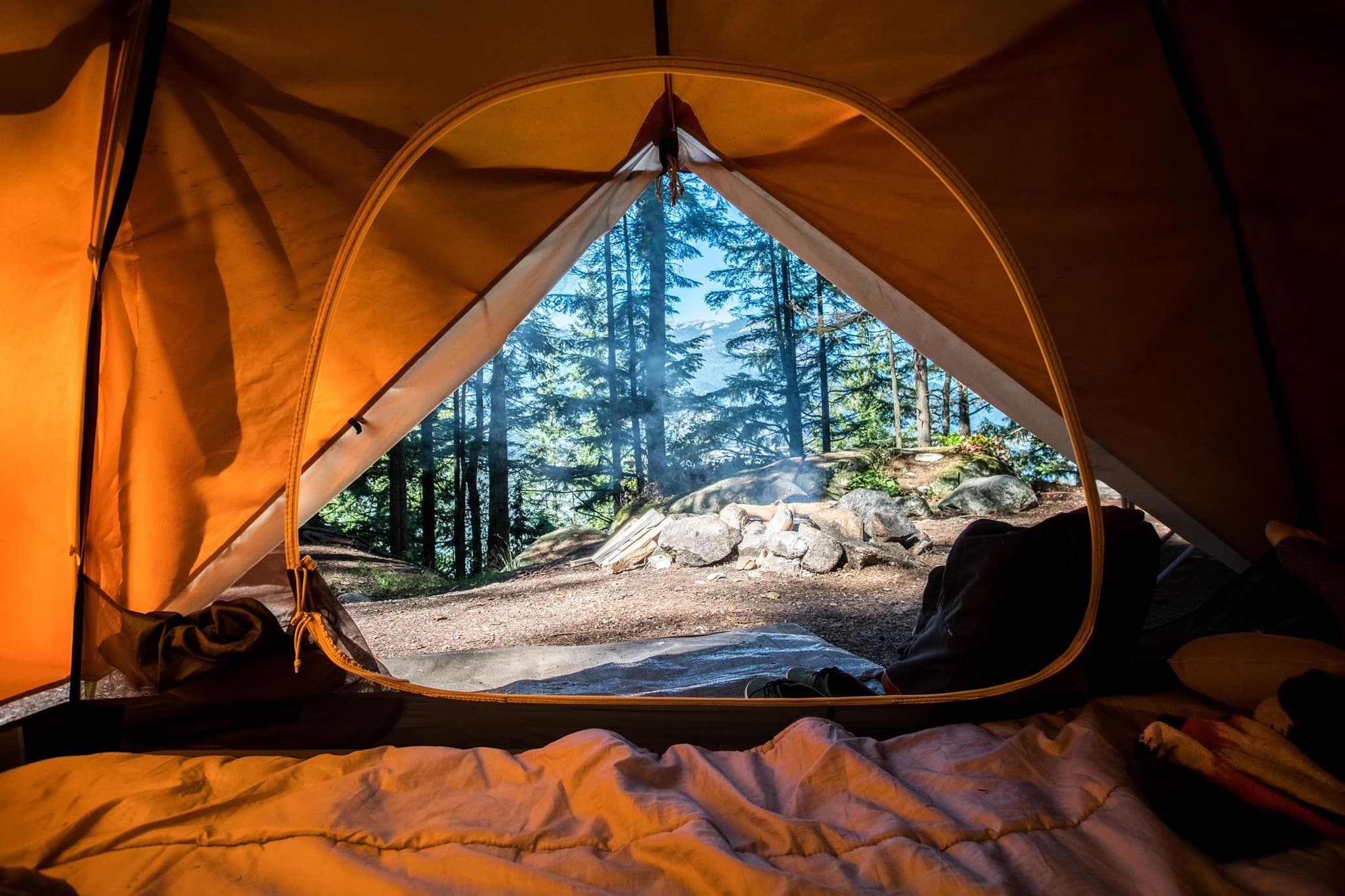 View through the open zipper of a tent in a forested area, USA.