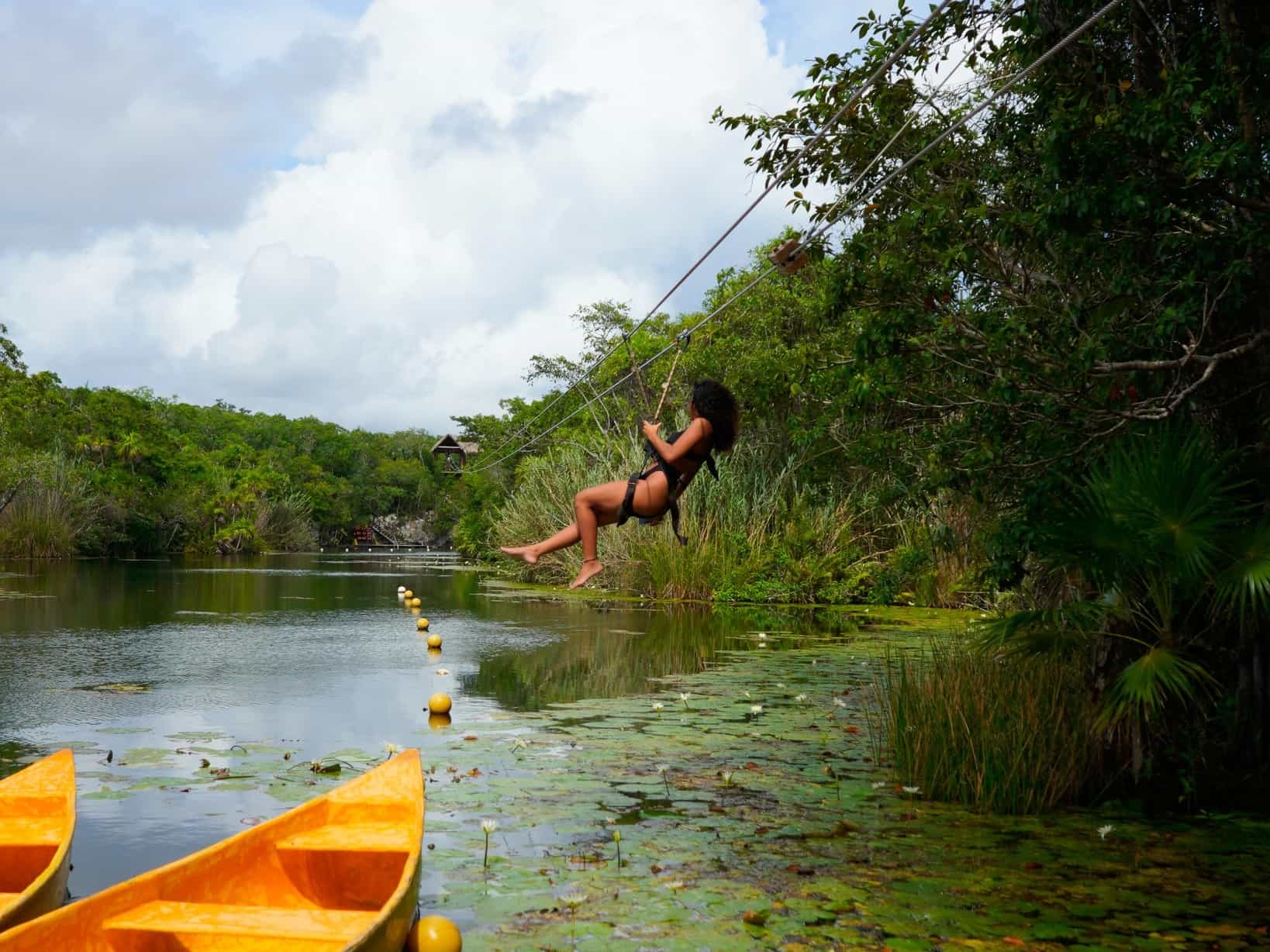A client ziplining into a cenote in Tankah Cenote Park, Mexico.