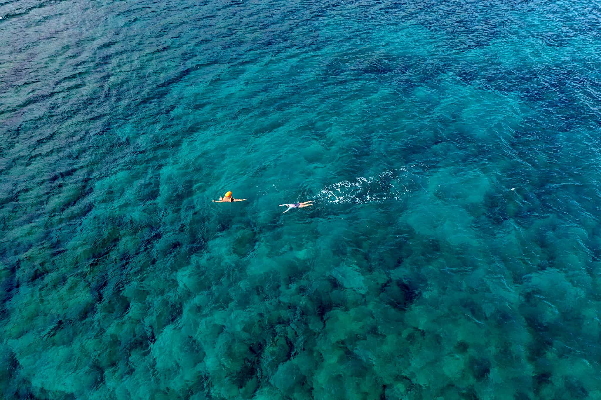 Drone shot of some open water swimmers in the sea near Crete, Greece.