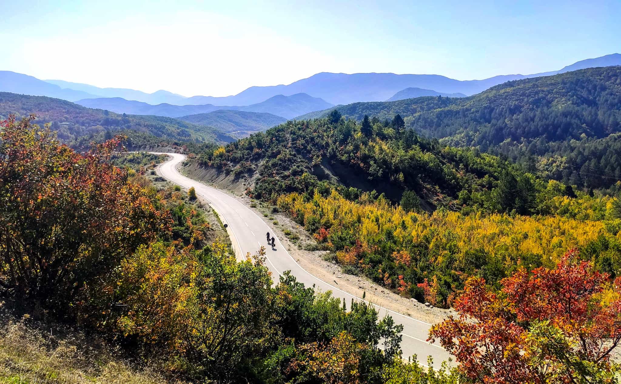 Two cyclists on a road in rural Albania