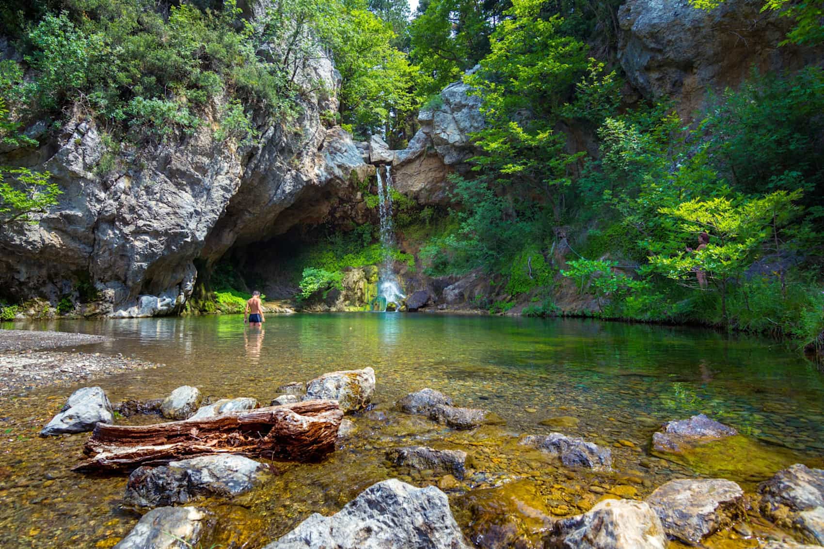 Man swimming at a waterfall natural pool on Evia Island, Greece