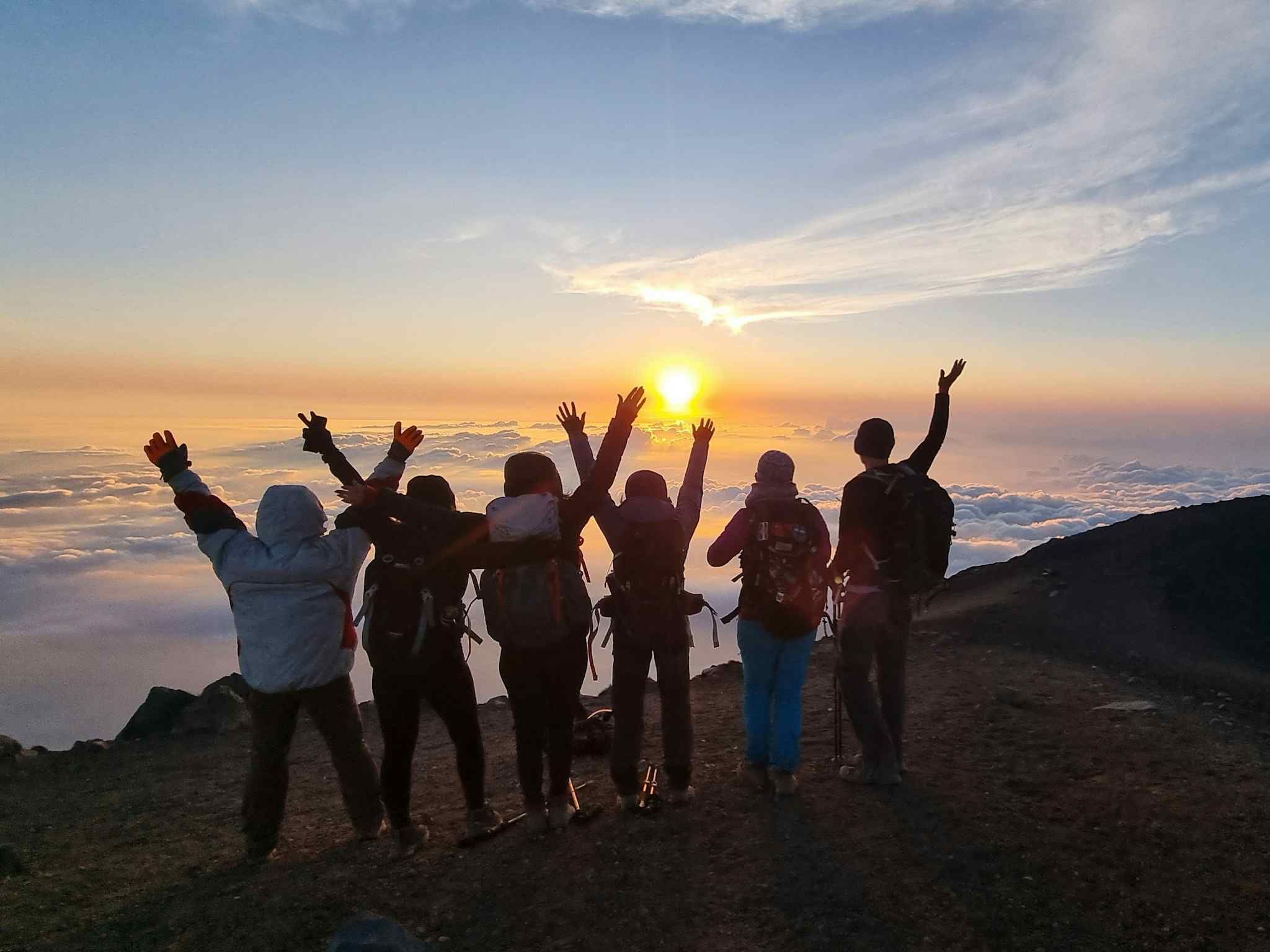 Group of hikers watching sunset at the summit of Acatenango, Guatemala.