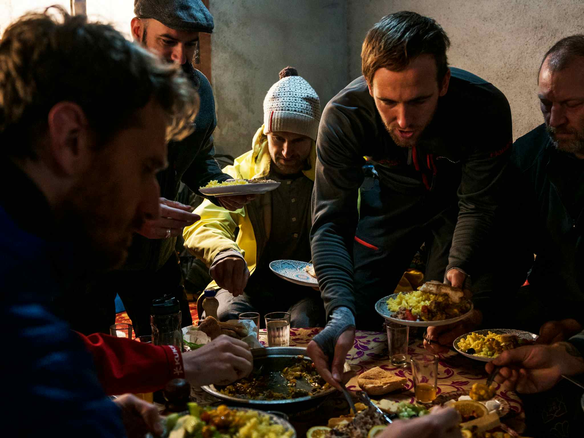 A group of hungry hikers help themselves to traditional Moroccan food. 