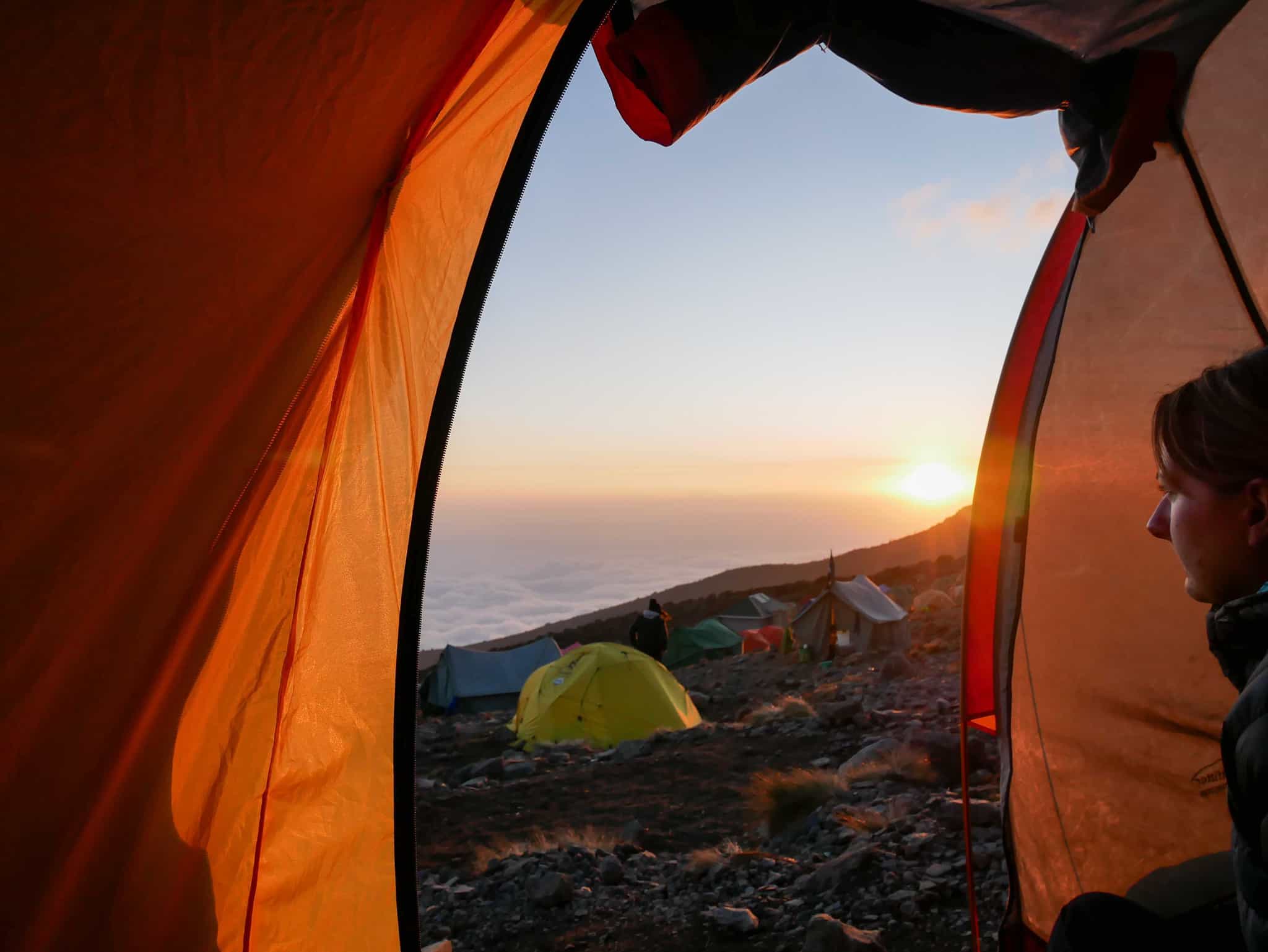 Woman looking at the view from inside a tent at Karanga Camp on Mount Kilimanjaro, Tanzania