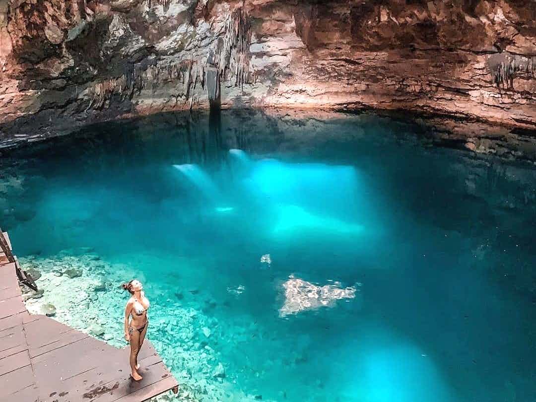 Traveller standing by a blue cenote in Mexico's Yucatan region.