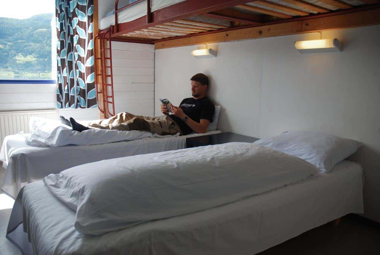 A man rests on a bed in a hostel in Voss, Norwegian Fjords. 