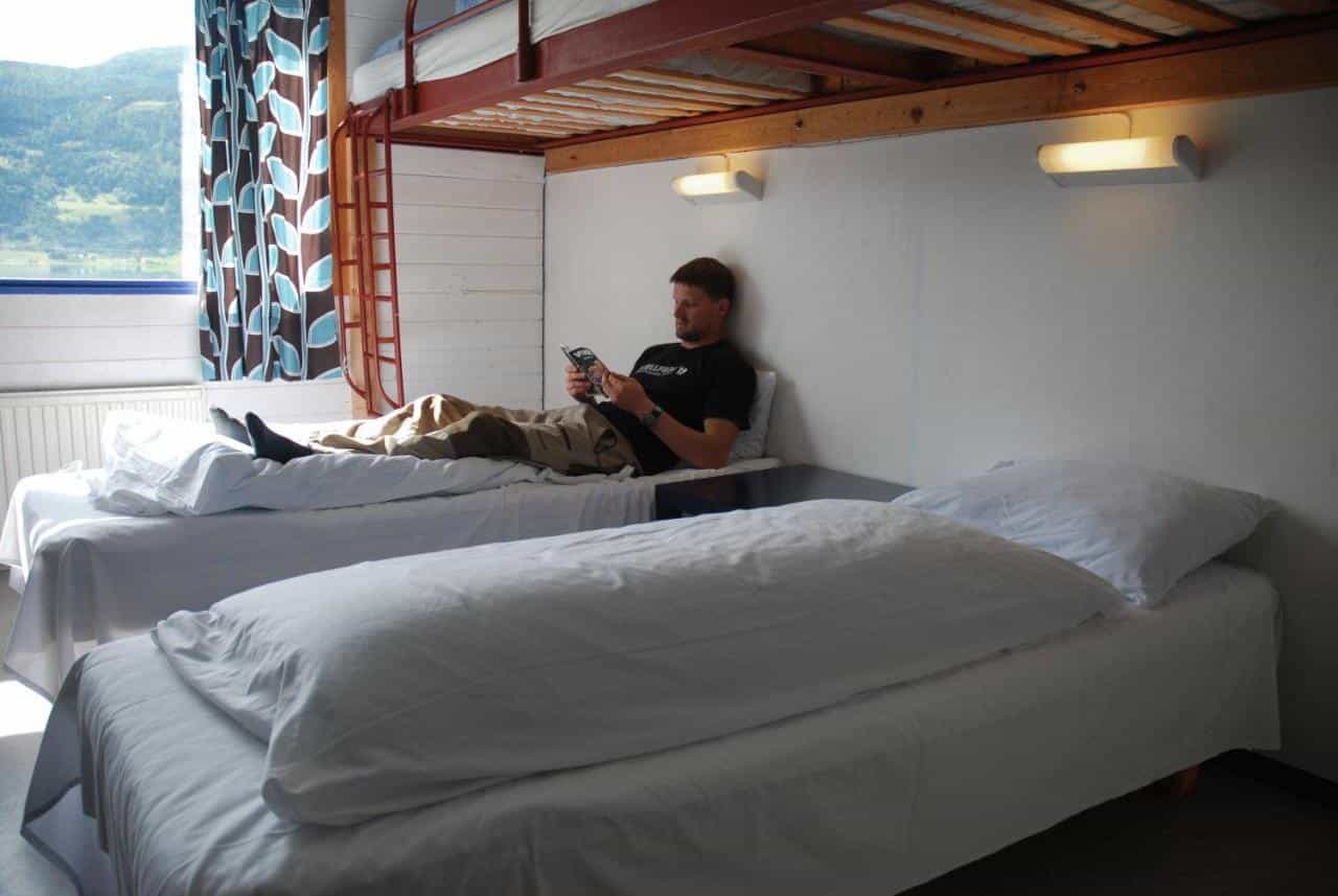 A man rests on a bed in a hostel in Voss, Norwegian Fjords.