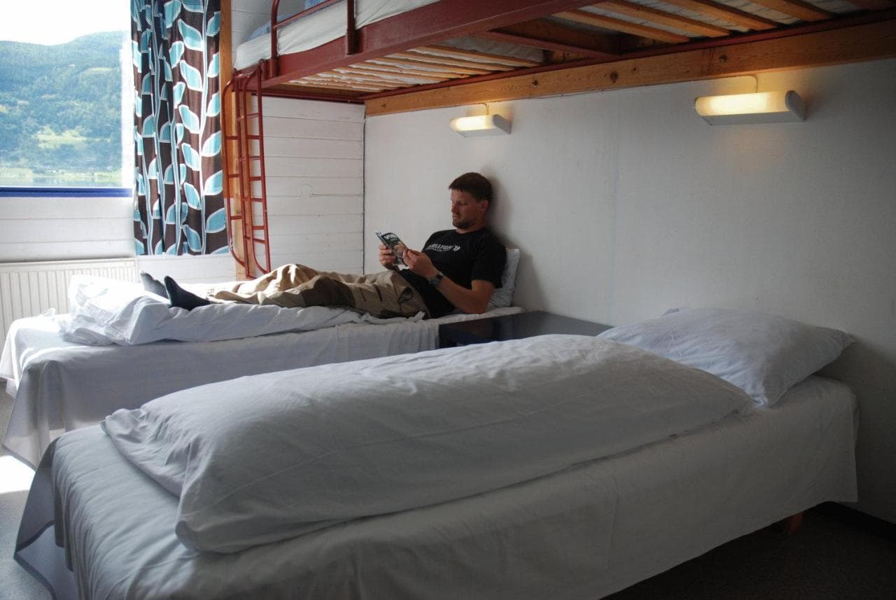 A man rests on a bed in a hostel in Voss, Norwegian Fjords.