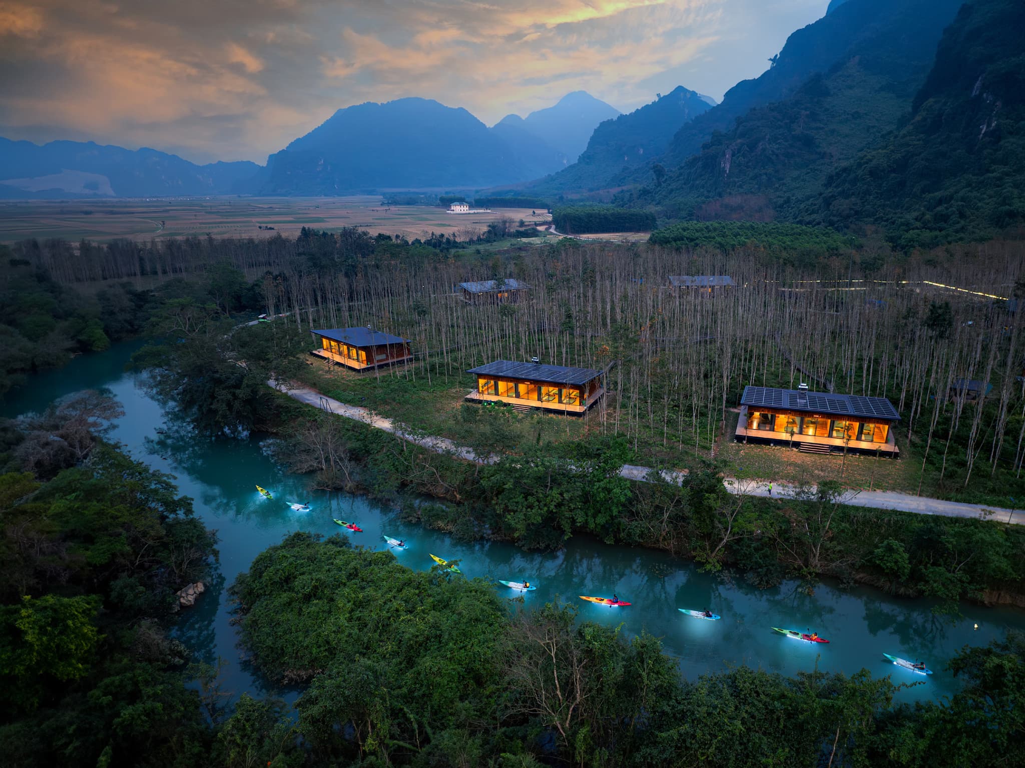 Kayakers passing the Blue Diamond Retreat in Phong Nha–Ke Bang National Park, Vietnam.