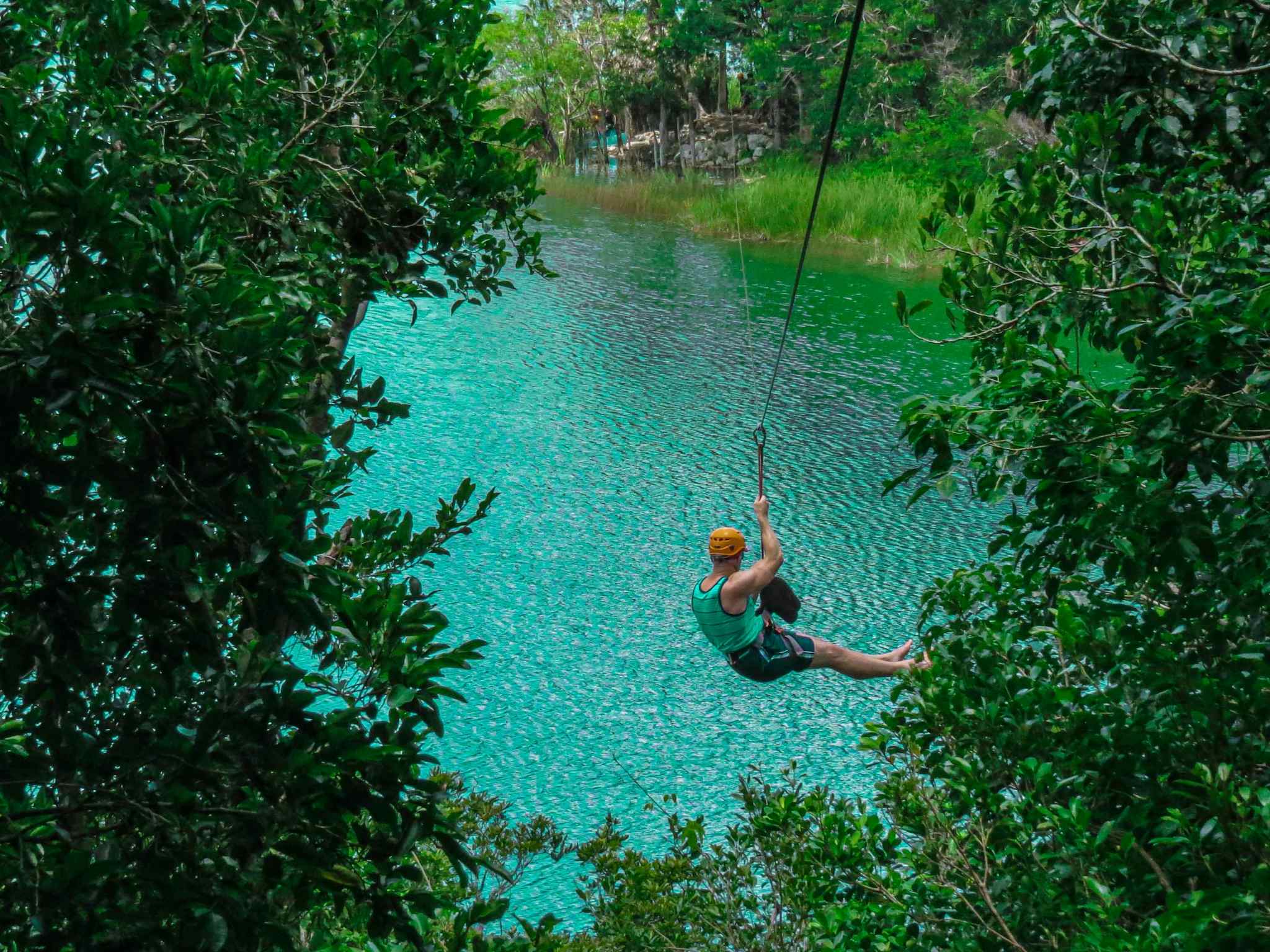 A tourist ziplining in Punta Laguna Reserve, Mexico.