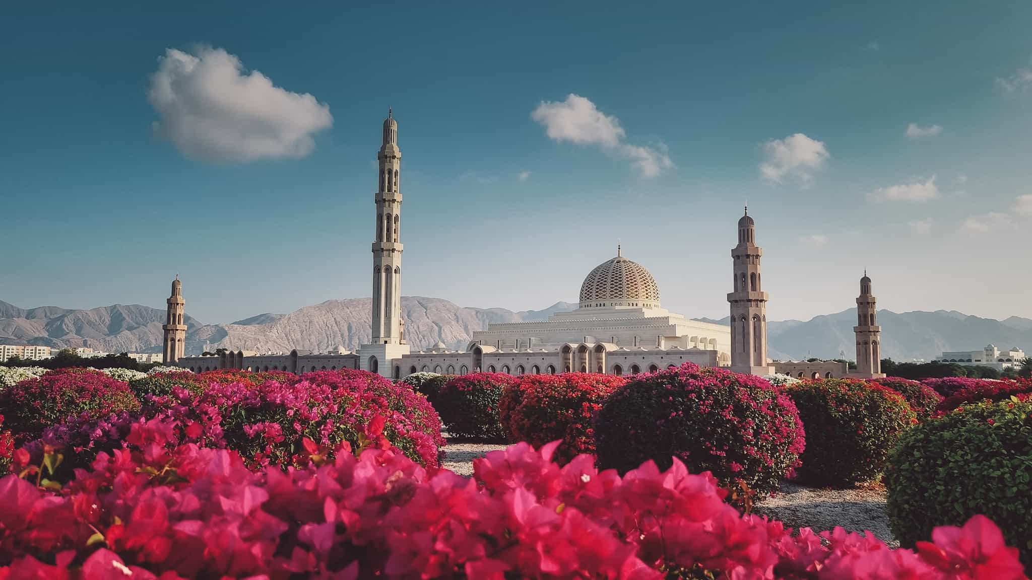 View of the Sultan Qaboos Grand Mosque in Muscat, Oman, with flowers in the foreground
