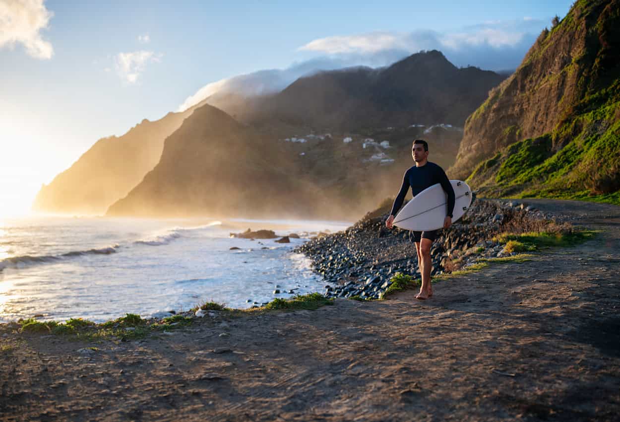 Surfer by Madeira's wild coast.