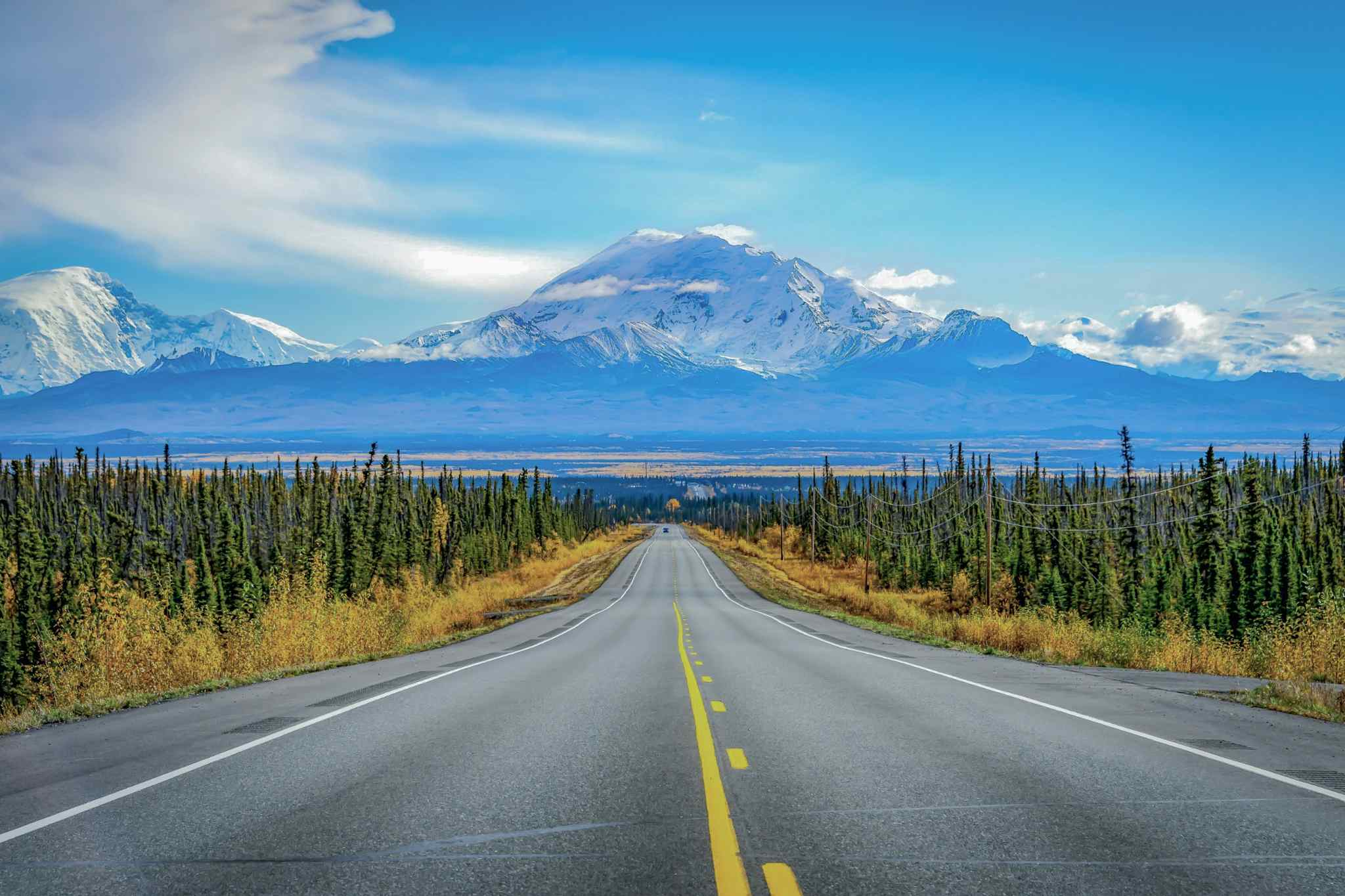 Highway in Alaska, USA. Pcoto: Canva: https://www.canva.com/photos/MADaudhus0k-alaska-road-trip-with-mountain-and-blue-sky/