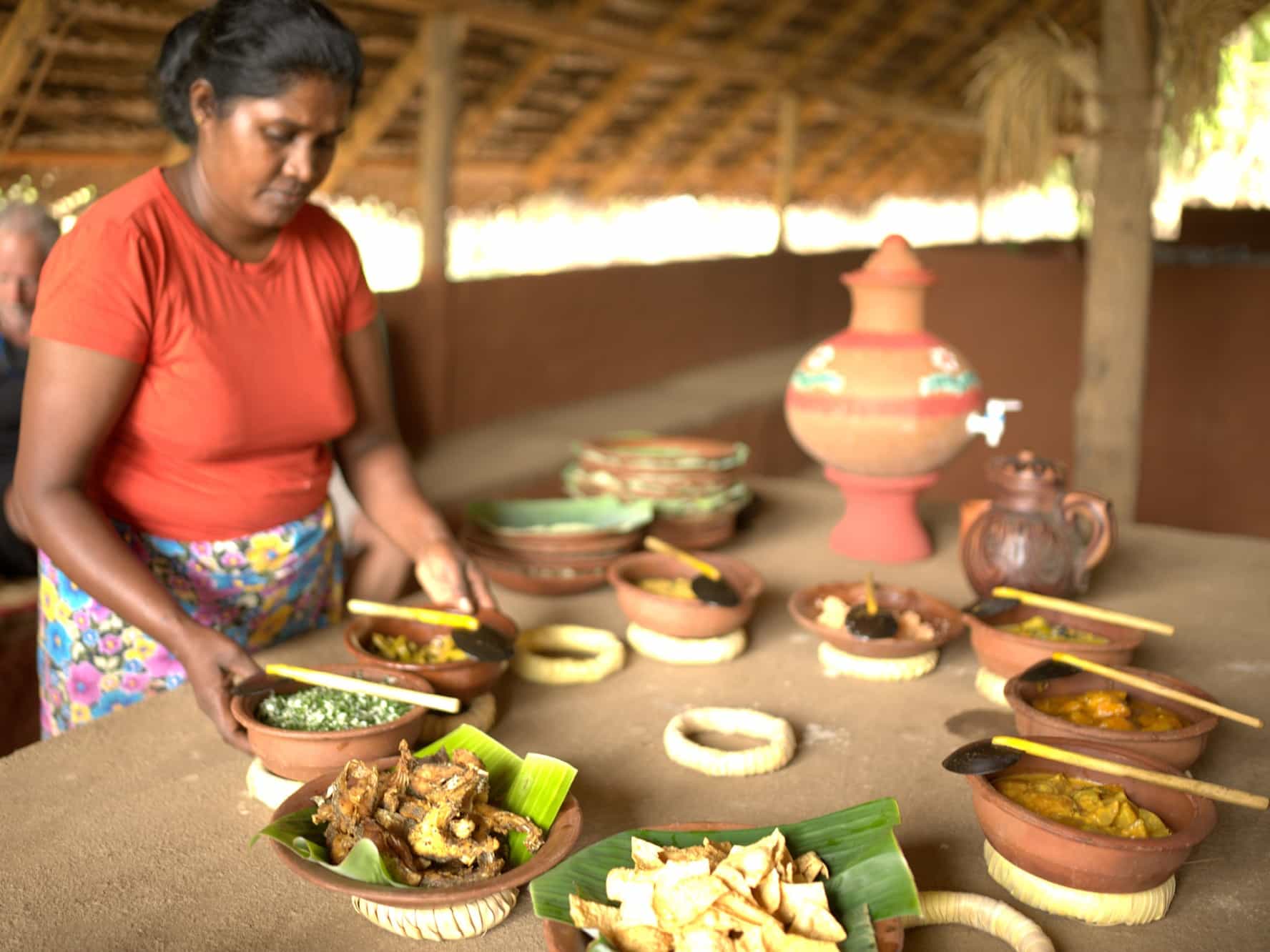 Sri Lankan women setting table for lunch, bowls of Sri Lanka food