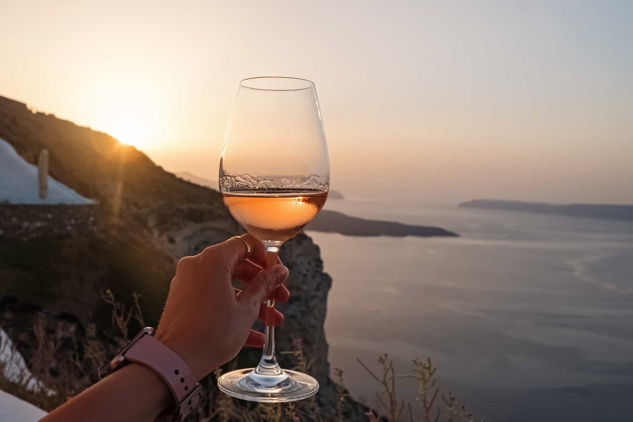 Glass of wine at sunset in the Cyclades Islands, Greece.