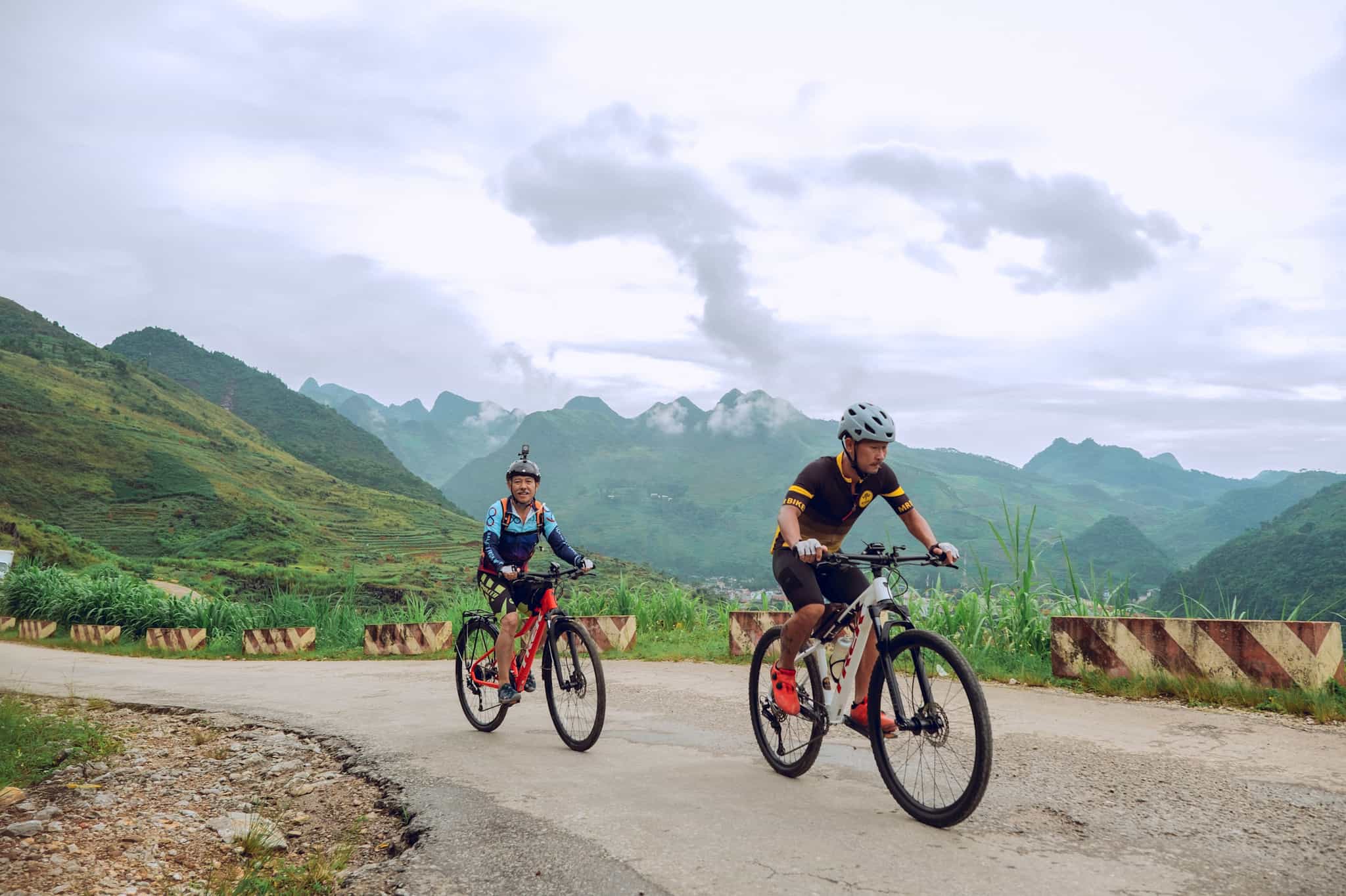 Two cyclists biking through North Vietnam.