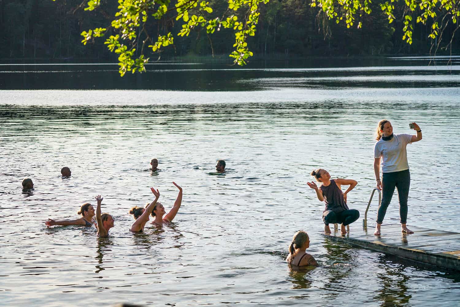 A group of wild swimmers taking a selfie in a lake, Sweden.