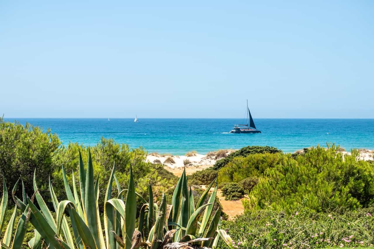 Boats passing in front of La Barrosa beach in Sancti Petri, Cadiz, Spain.