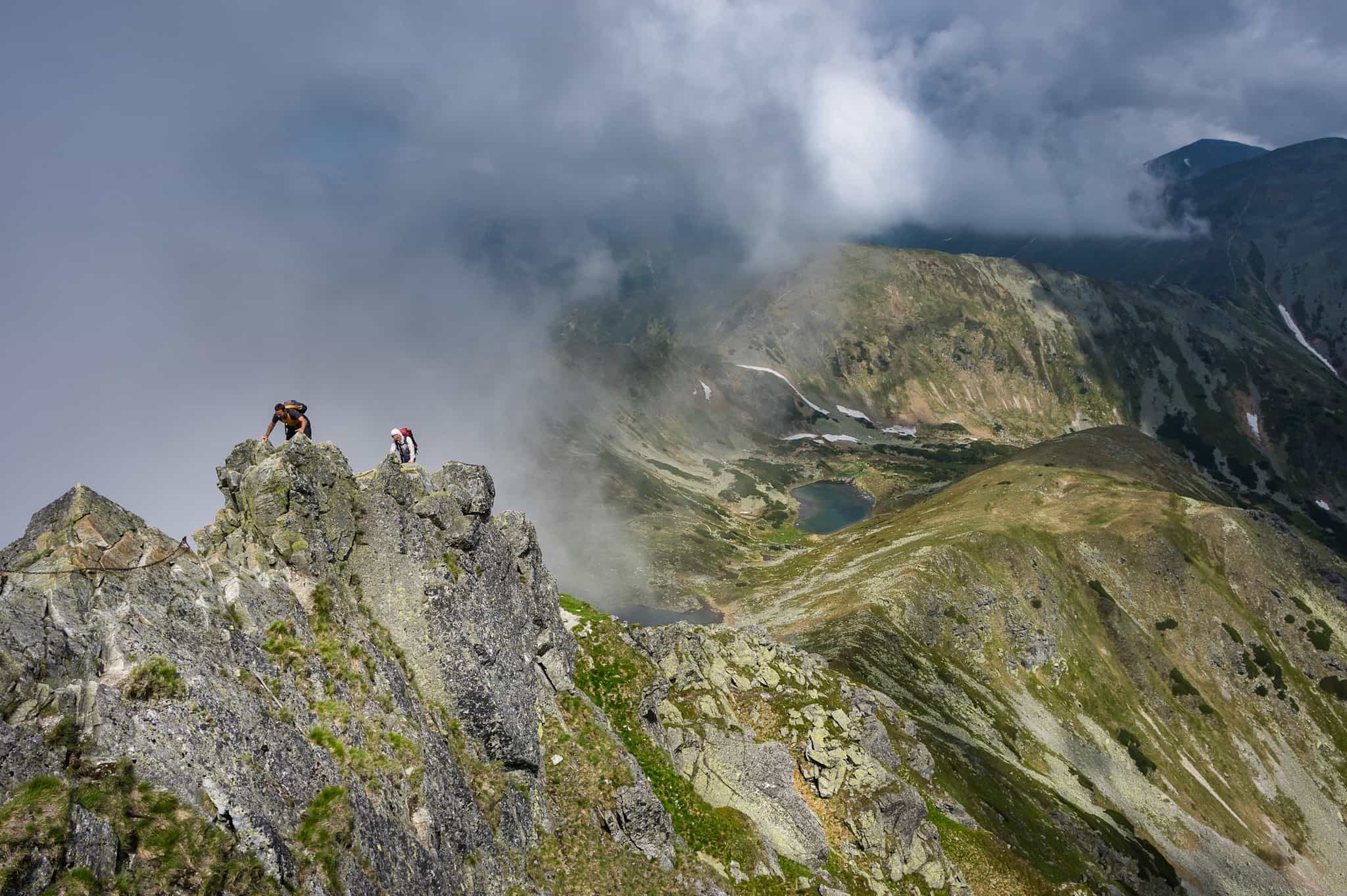 Two hikers scramble along the ridge to Starorobociański Wierch in the Polish Tatras